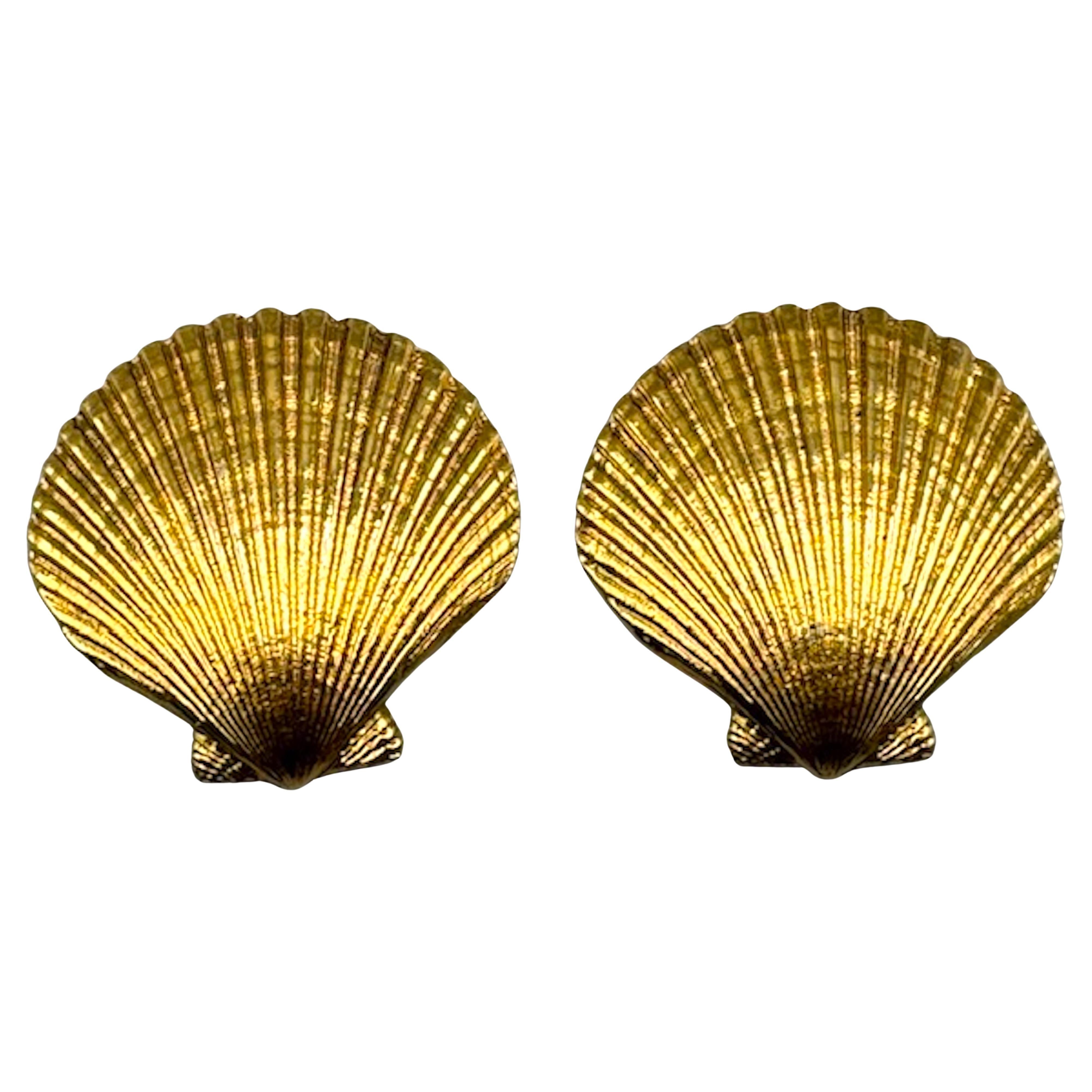 Dieses atemberaubende Paar Vintage-Ohrringe von YSL (Yves Saint Laurent) zeichnet sich durch ein hübsches Muschelmotiv in einem satten Goldton aus. Sie sind dreidimensional, haben eine gewölbte Form und sehen aus, als wären sie aus einer echten