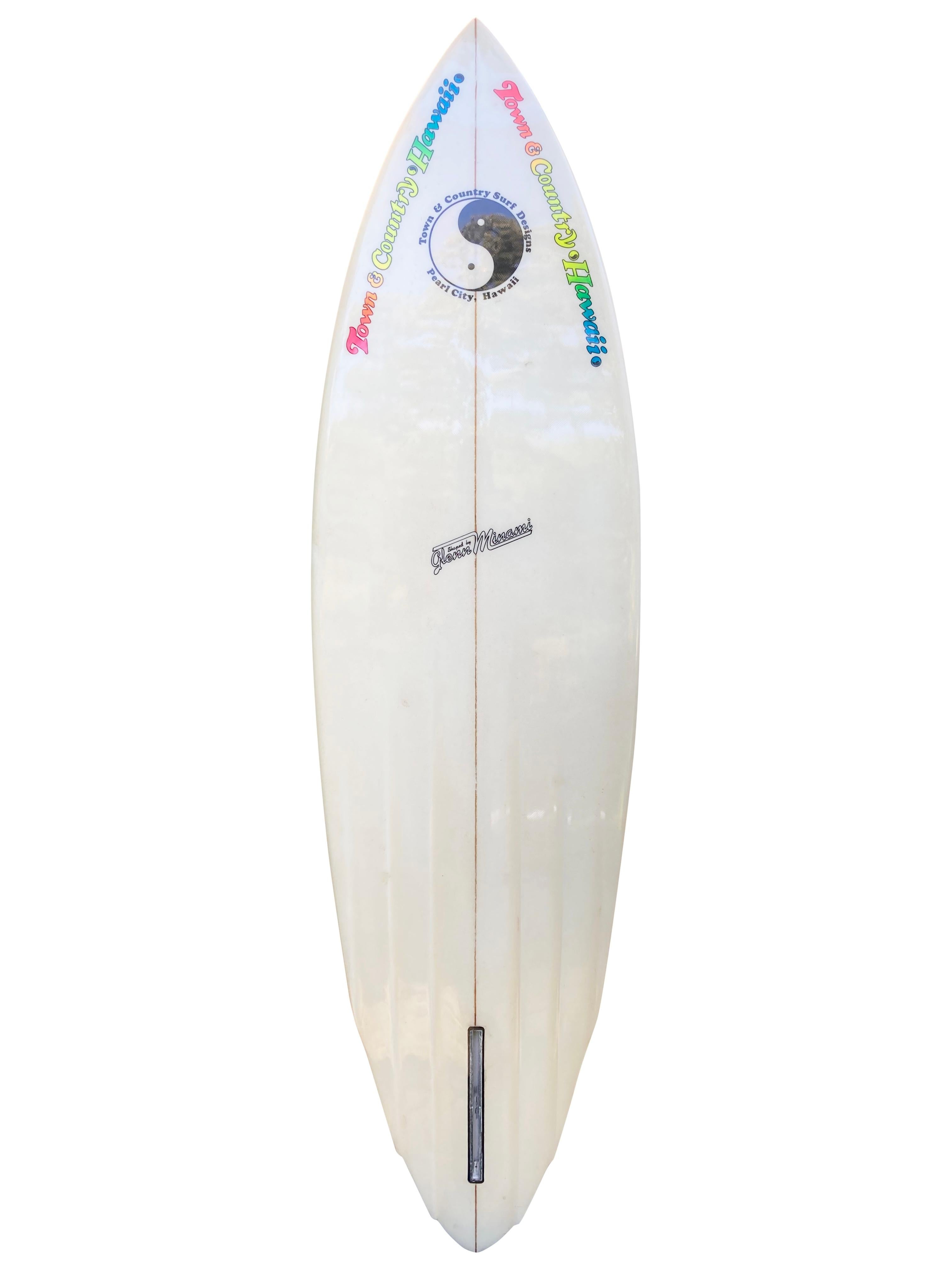 1981 vintage Town and Country surfboard made by Glenn Minami. Features a rounded pintail shape design with channel bottom built for speed. Beautiful blue retro 80s airbrush design. An incredible example of an early 1980s vintage surfboard made under
