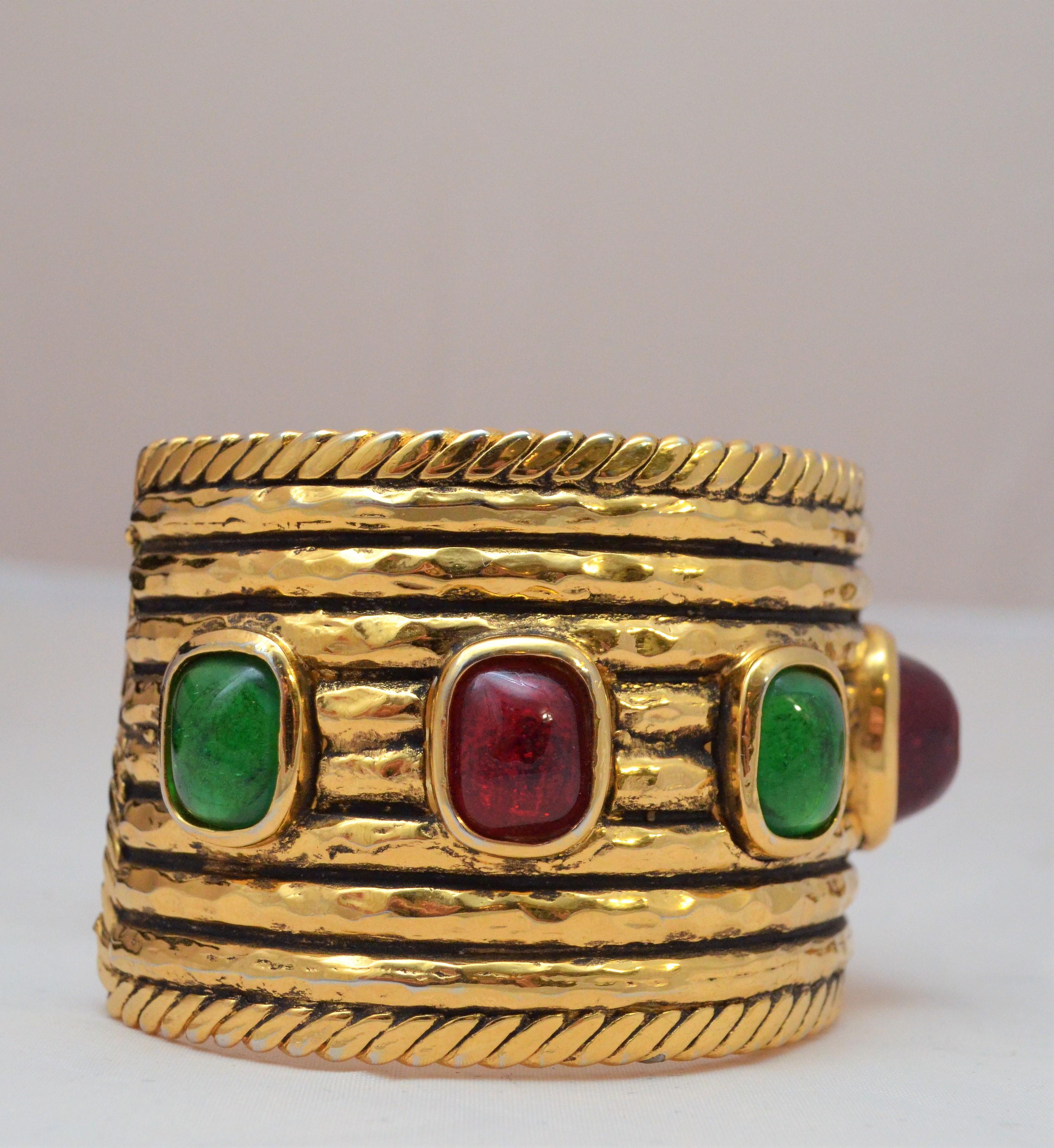Vintage 1990's Chanel Gold Cuff with red and green Gripoix poured glass stones -- Cuff featured in 24k plated gold with red and green glass gripoix stones. Cuff is from 1984. Measures 9.25” with a 1” opening. Excellent vintage condition. Designer