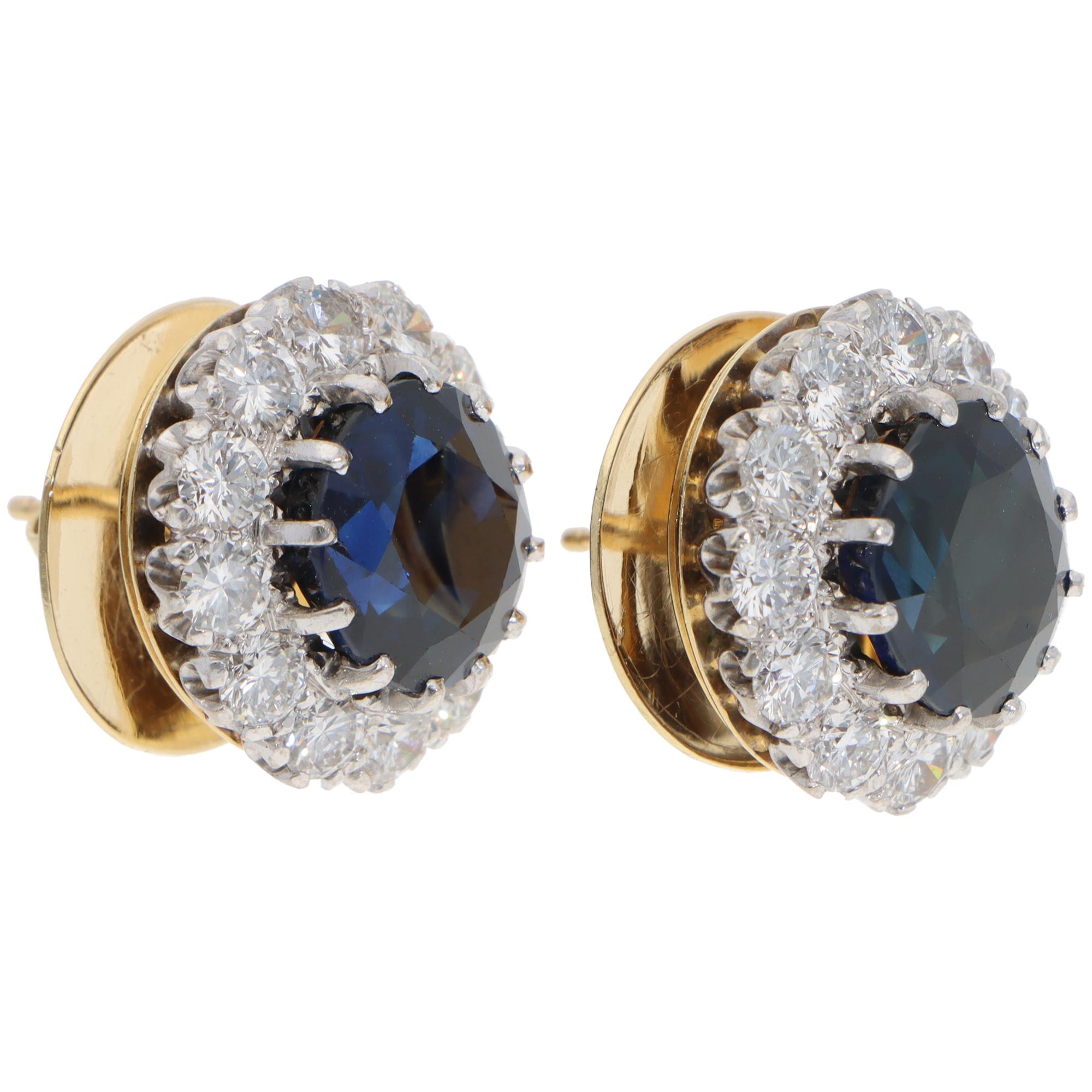 Ein atemberaubendes Paar Vintage-Ohrstecker von Garrard mit Saphiren und Diamanten in 18 Karat Weiß- und Gelbgold aus dem Jahr 1990.

Jeder Ohrring zeigt ein Blumenmotiv mit einem tiefblauen Saphir in der Mitte, umgeben von 12 runden Diamanten im