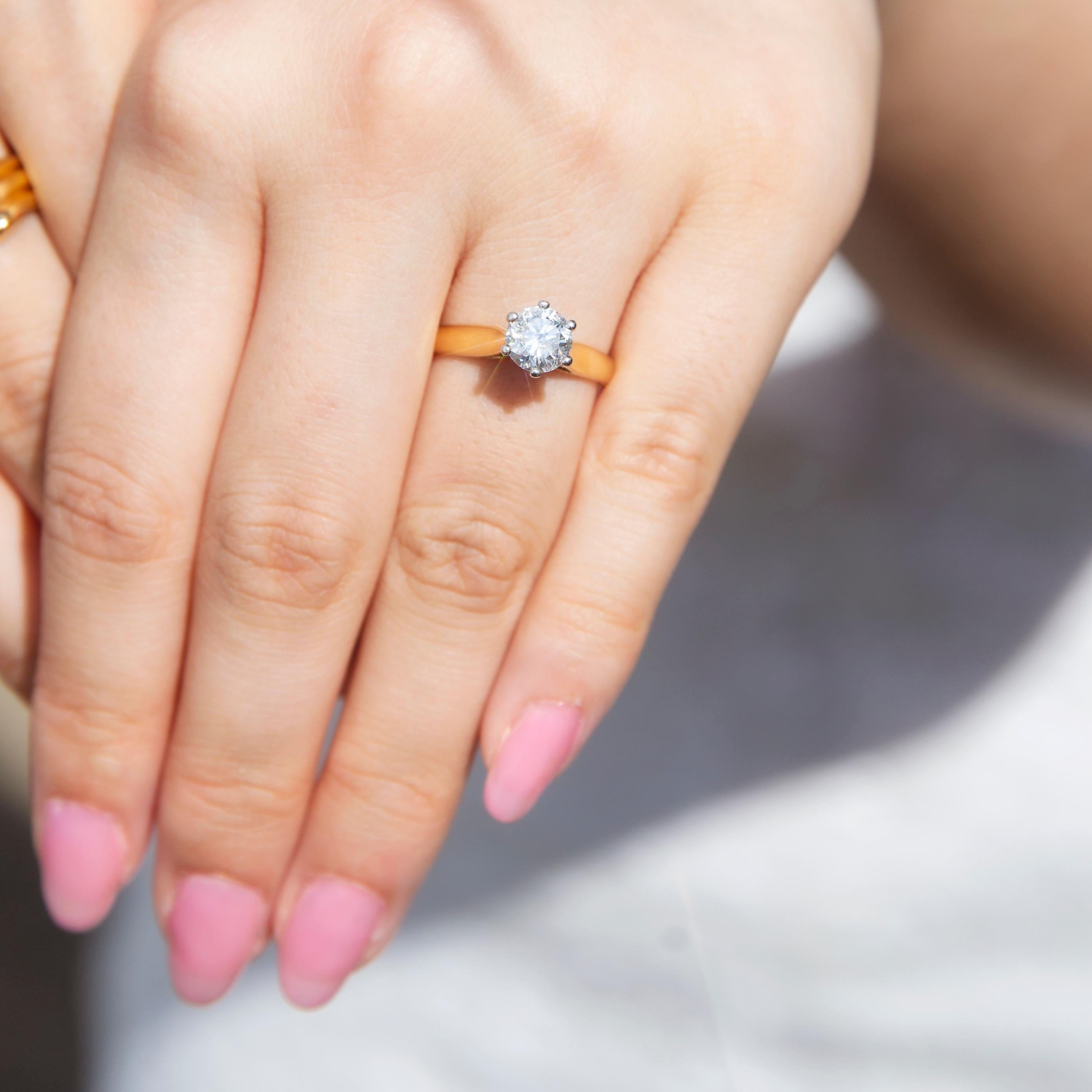 Dieser atemberaubende Vintage-Ring aus 18 Karat Gelbgold (ca. 1990) ist mit einem fabelhaften runden Brillanten von 1,01 Karat besetzt, der in einer erhöhten Krallenfassung auf einem Hochglanzband ruht. Dieses fabelhafte Stück trägt den Namen