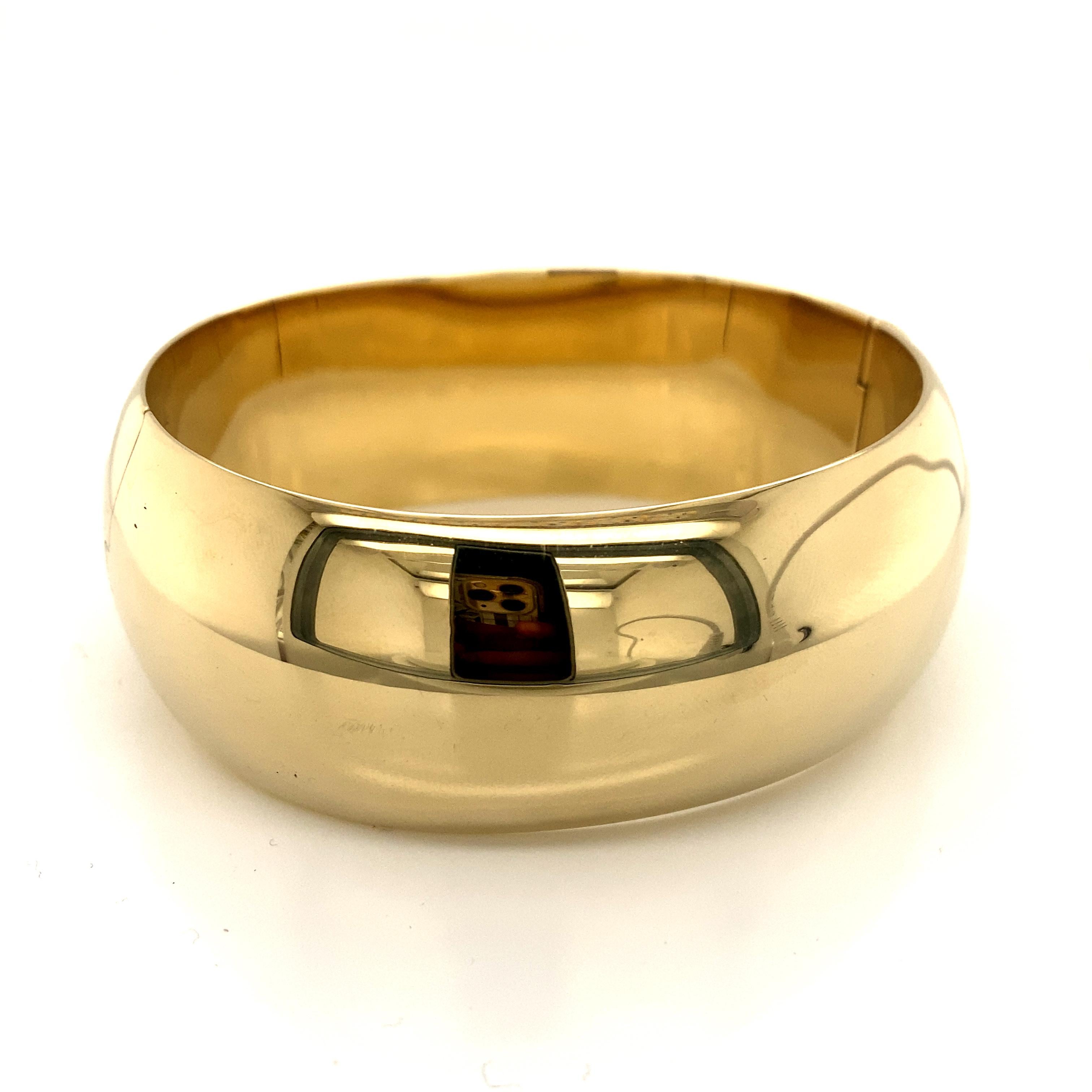 This stunning vintage bangle bracelet from the 1990s is a true statement piece that exudes timeless elegance and luxurious appeal. Crafted from solid 14k yellow gold, it showcases the enduring allure of classic gold jewelry.

The bracelet's striking
