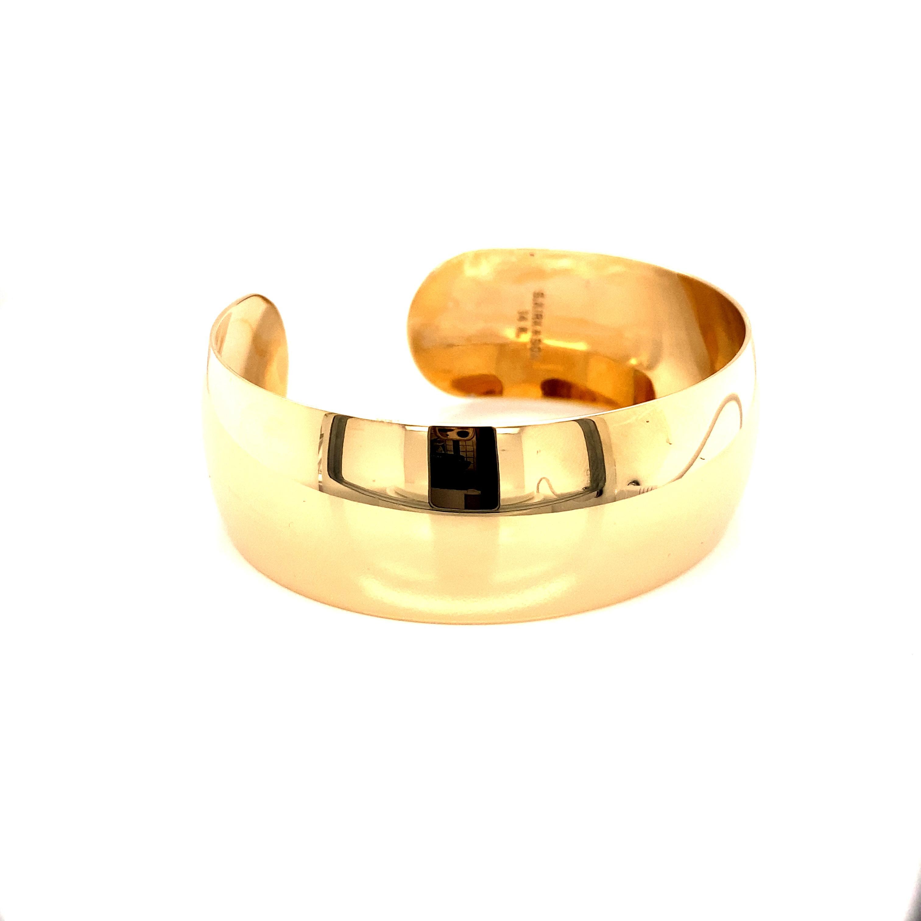 Exuding minimalist glamour, this vintage 14k yellow gold cuff bracelet from the 1990s makes a bold, contemporary statement. The bracelet takes the form of a substantial wide cuff that wraps regally around the wrist. With a substantial width of 0.88