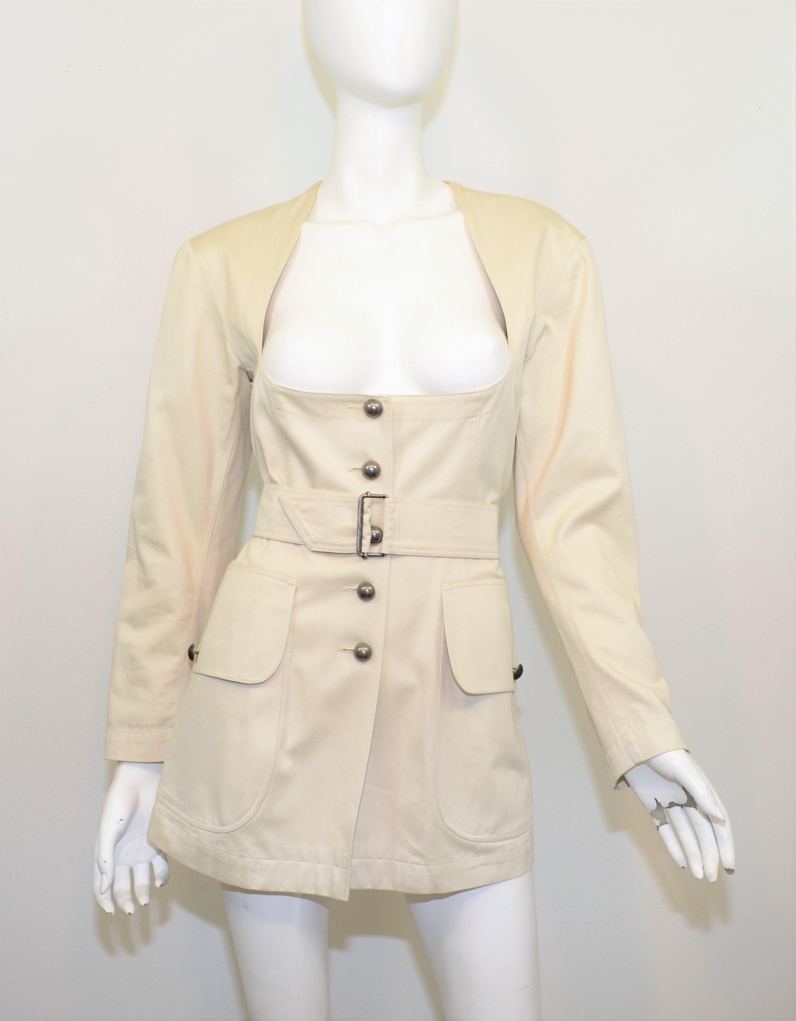 Vintage Alaia jacket is featured in a neutral khaki color with a deep cut neckline, button fastenings, and a belted closure. Jacket is fully lined, labeled size FR 40, made in France, 100% cotton. Excellent vintage condition with minimal wears