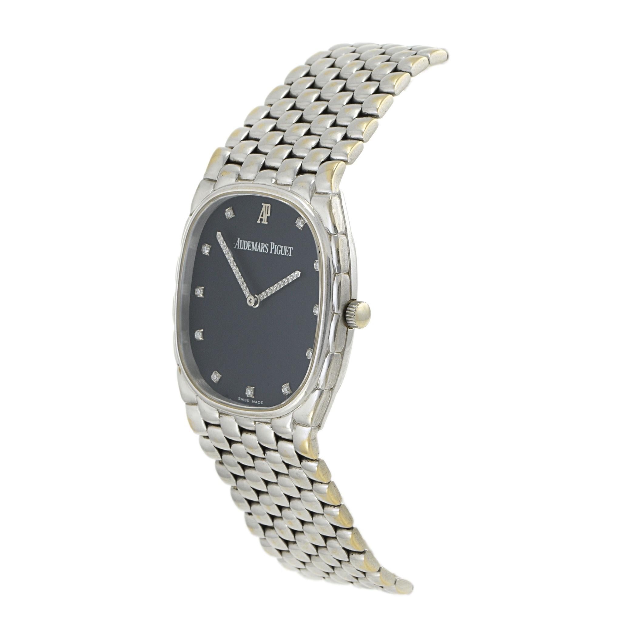Cette Audemars Piguet Cobra vintage, circa 1990, présente un boîtier de 29 mm en or blanc 18KT associé à un bracelet à maillons de style brique assorti. Le cadran bleu marine est élégamment rehaussé d'index et d'aiguilles sertis de diamants, offrant
