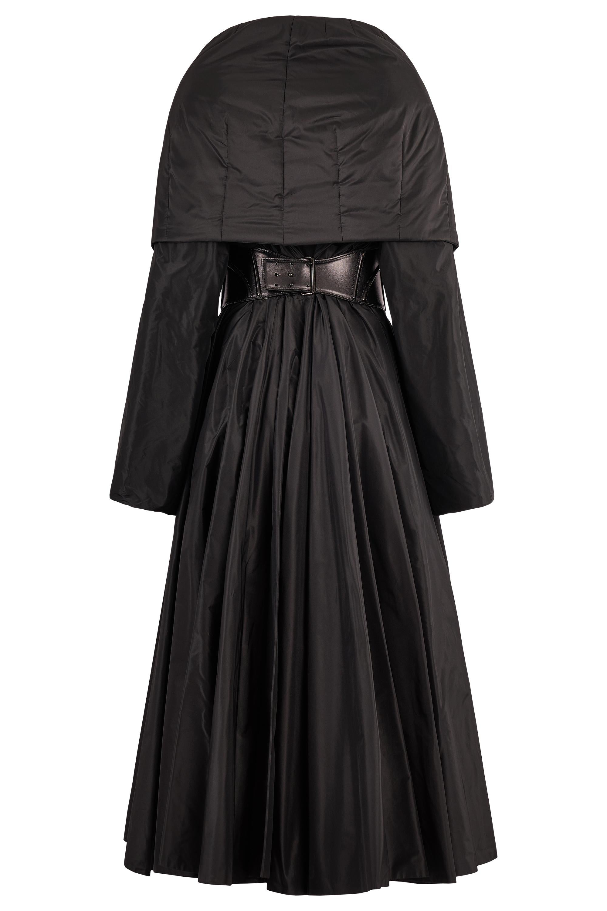 Abrigo largo acolchado Azzedine Alaïa vintage, negro, con cinturón corsé de piel. Este asombroso abrigo presenta un volumen espectacular con una sastrería escultural. Confeccionado en un lustroso tejido acolchado negro, el diseño presenta un cuello