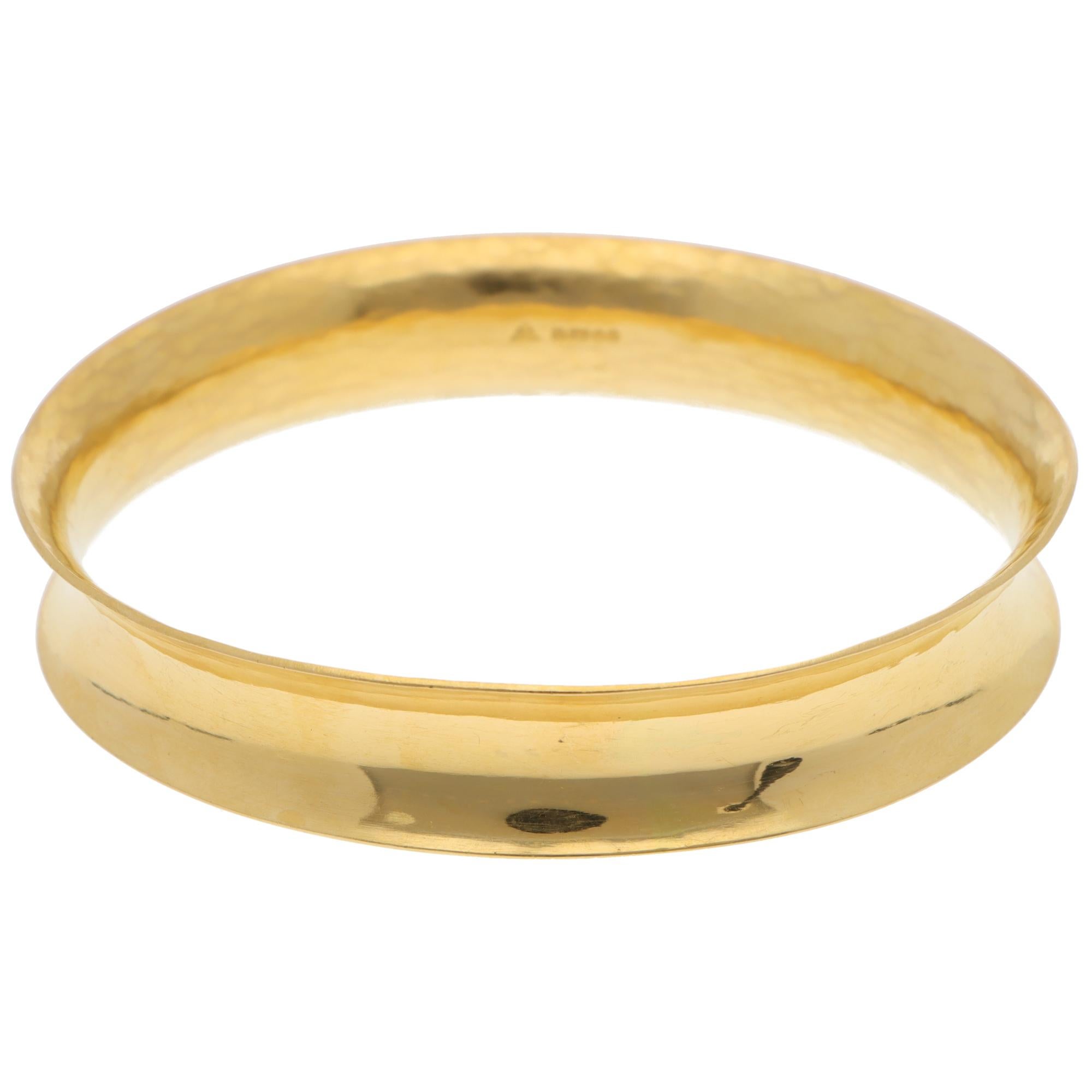 Un bangle concave en or jaune 22k des années 1990, extrêmement unique en son genre.

Le bracelet est composé dans un design concave en or jaune 22k massif avec un subtil effet martelé à l'intérieur. En raison de son design et de son style, ce