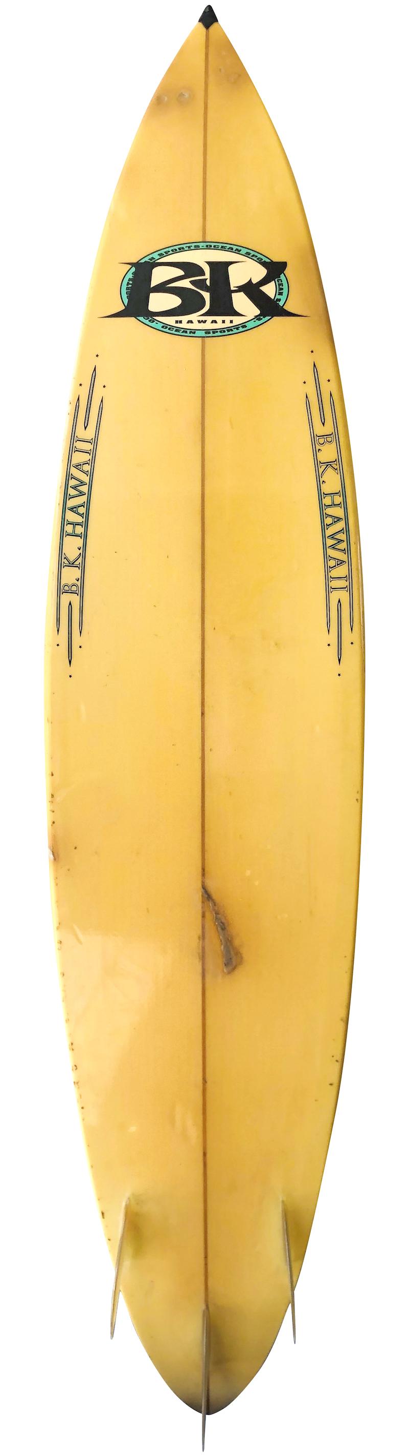 Early 1990s BK Hawaii thruster (tri-fin) surfboard shaped by Barry Kanaiaupuni. Features a rounded pintail design with glassed on fins. This vintage surfboard remains in all original condition.

Barry Kanaiaupuni is best known for his dominance at