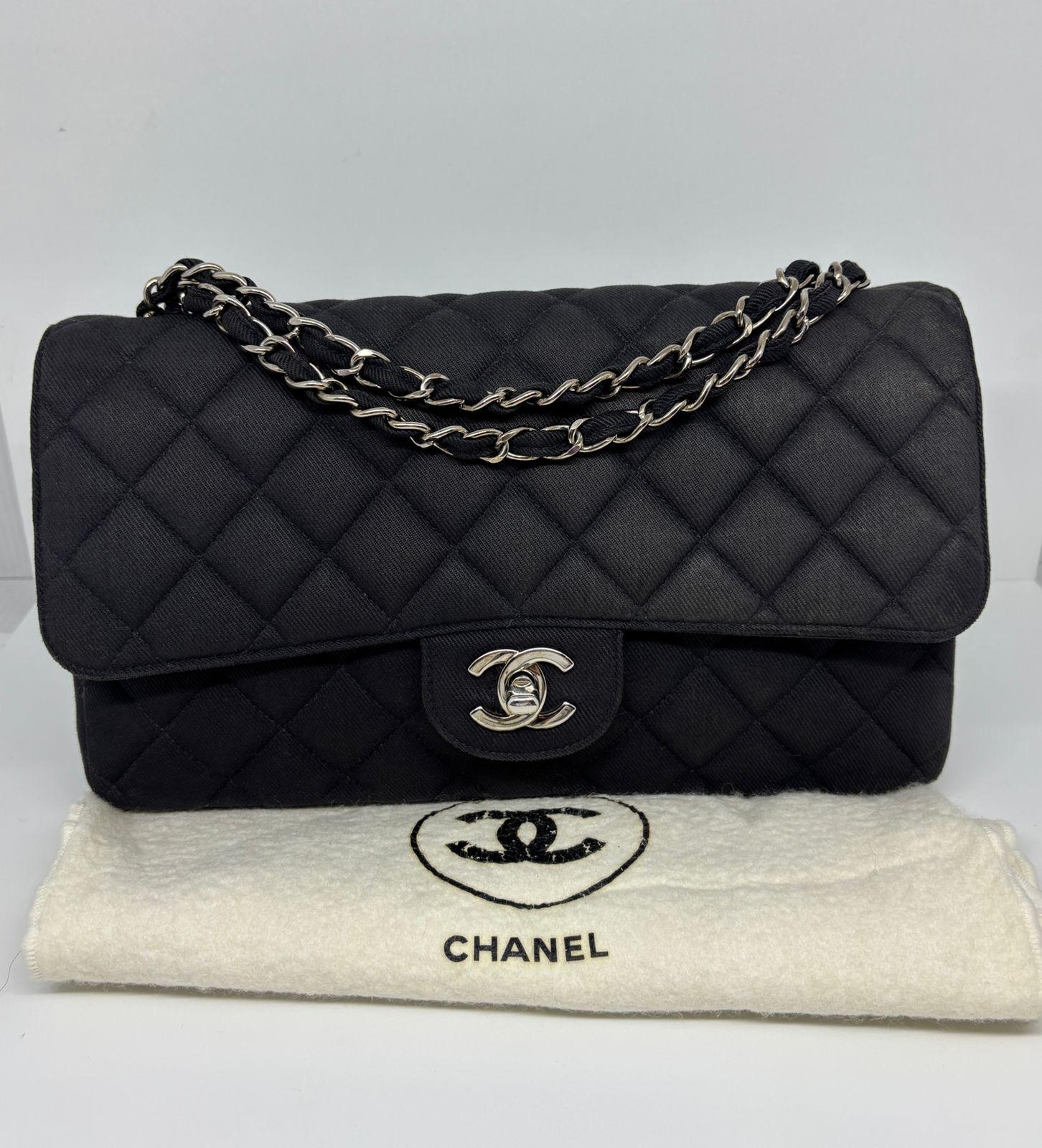 Classic chanel medium flap in black canvas with silver hardware.. Very lightweight. Slight rubbing on the corners, minor touch ups has been done on the corners. Slight rubbing throughout the bag, the canvas felt a little sleek. Minor white marks on