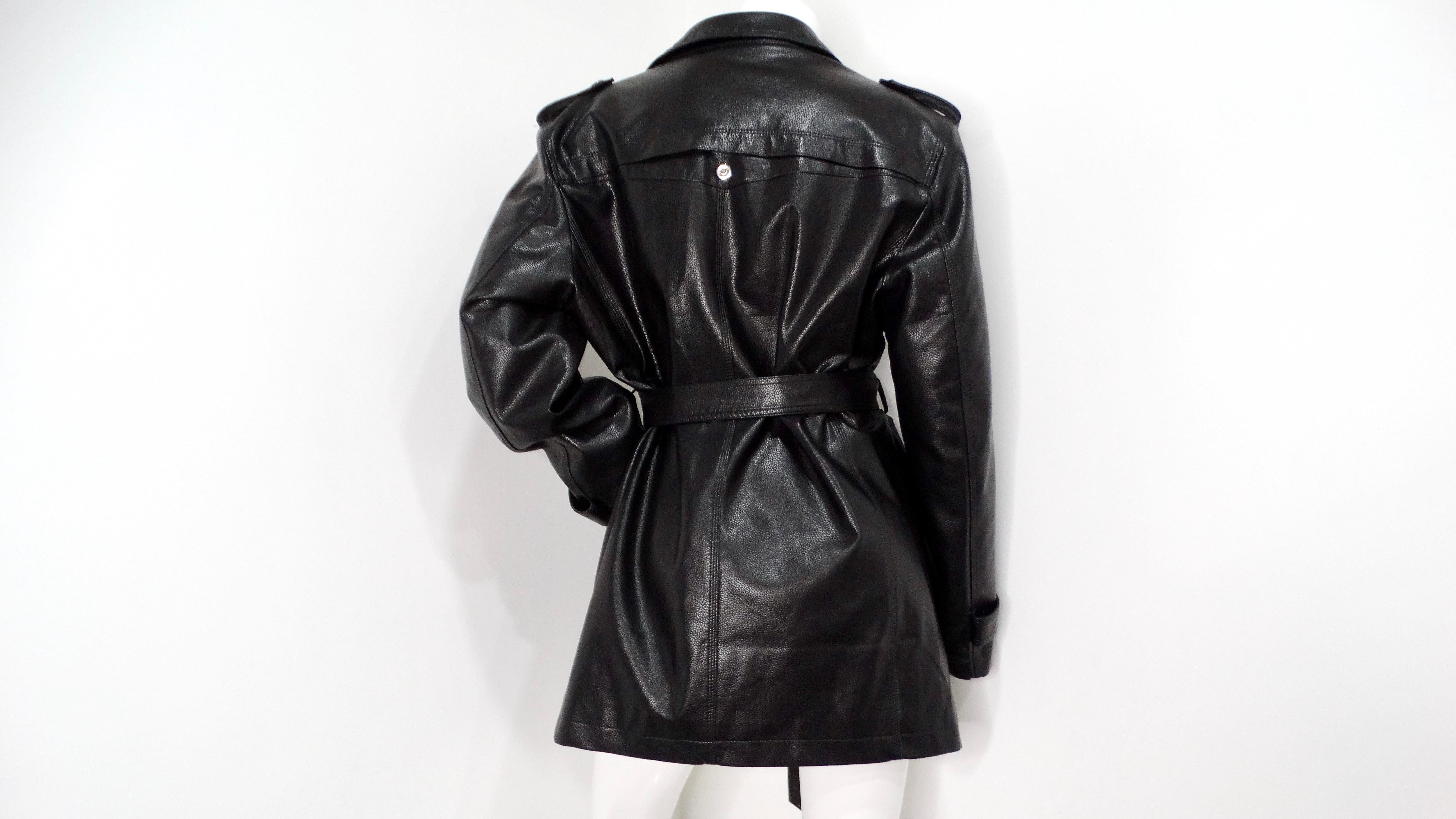 Step into a world of timeless elegance with this stunning Vintage 1990s Black Leather Trench Mini Dress Jacket With Belt. This exquisite piece effortlessly combines the edgy allure of leather with a classic trench design, making it a must-have for