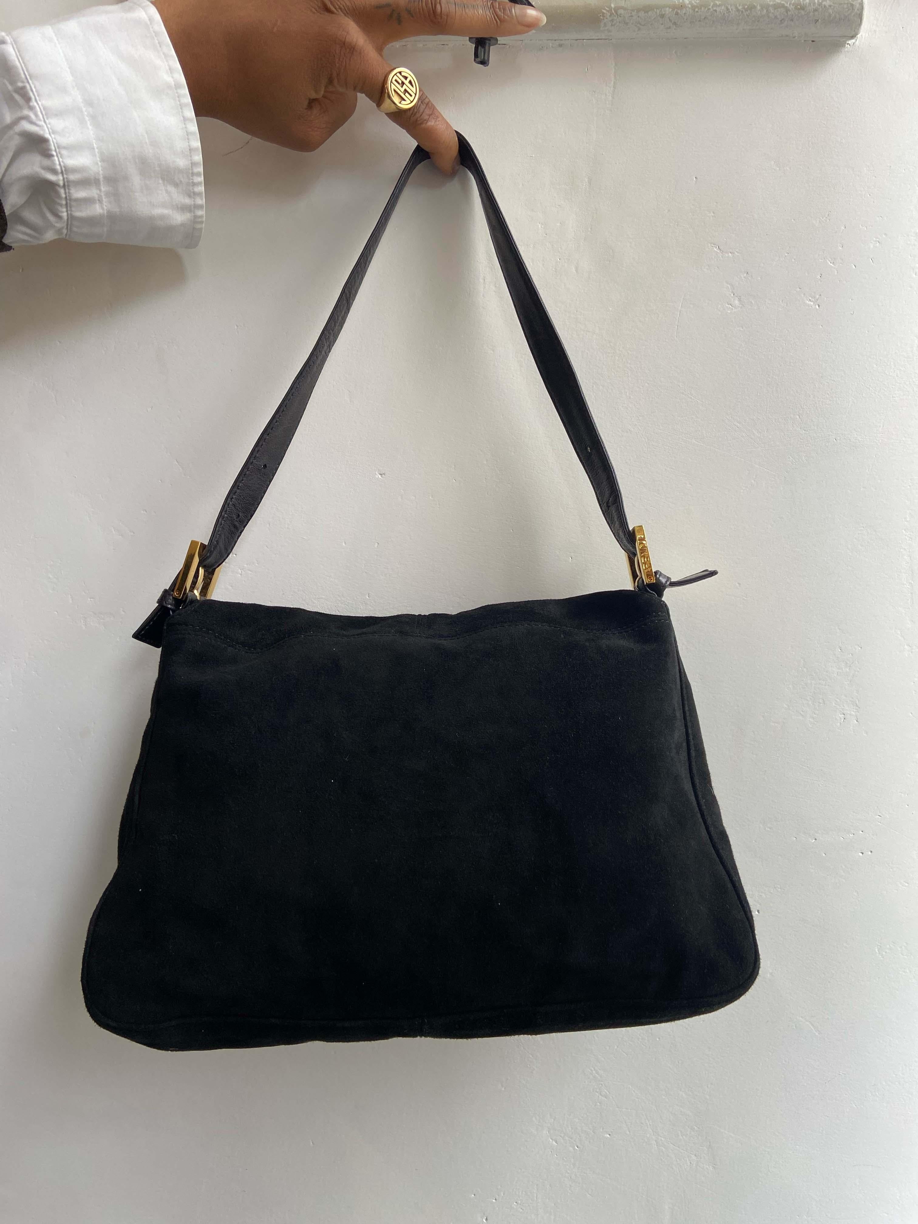 Vintage late 1990’s Fendi Mamma baguette bag .Features a black suede fabric. Iconic Fendi gold and black leather front flap with magnetic closure, branded hardware buckles and red satin lining with a zip inner back pocket. In excellent vintage