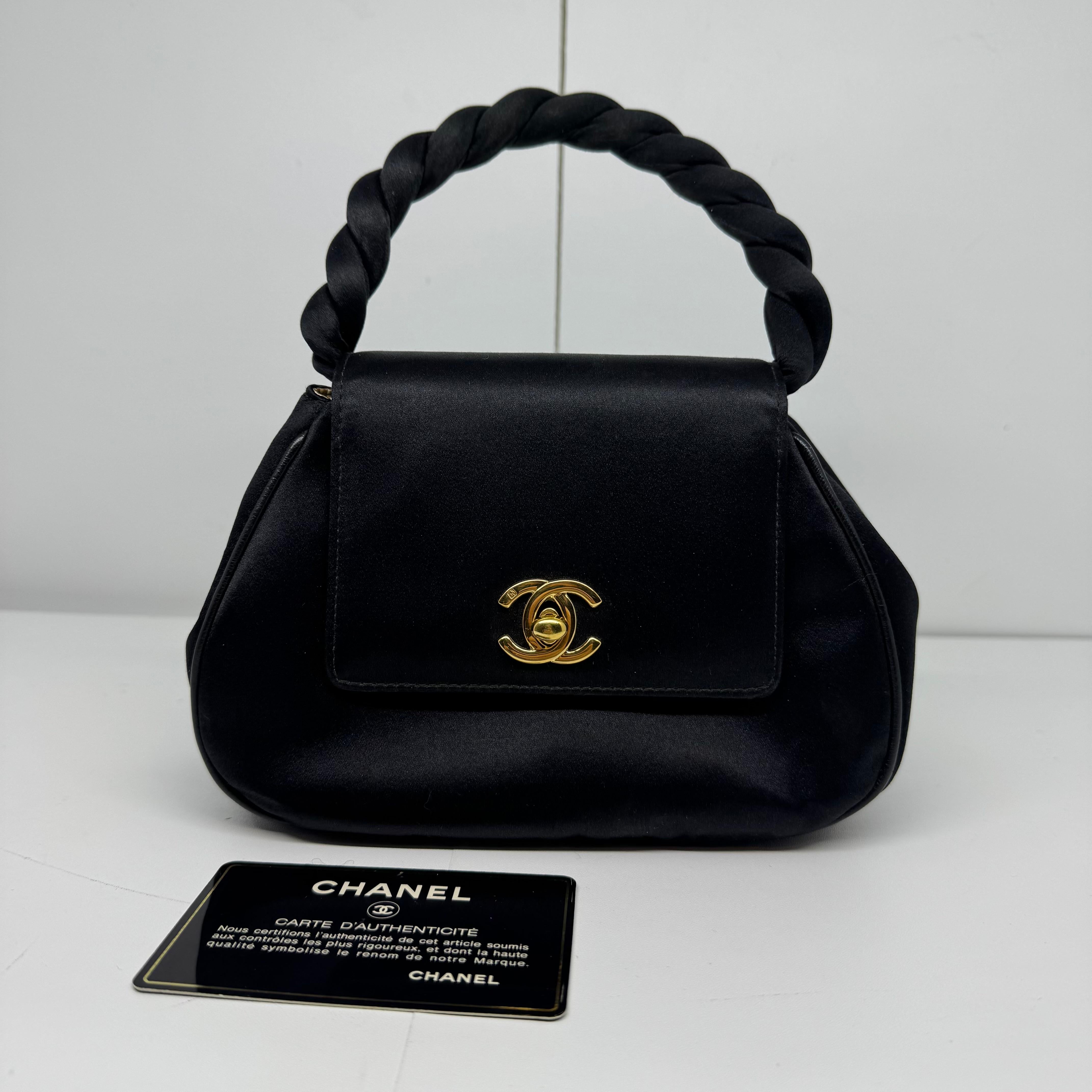Sac à main vintage en satin noir avec poignée tournante. Très bel état vintage, sans frottement sur la surface de la soie et les coins. Léger décollement de la doublure en cuir doré. Série n°4. Livré avec son holo intact et sa carte d'authenticité.