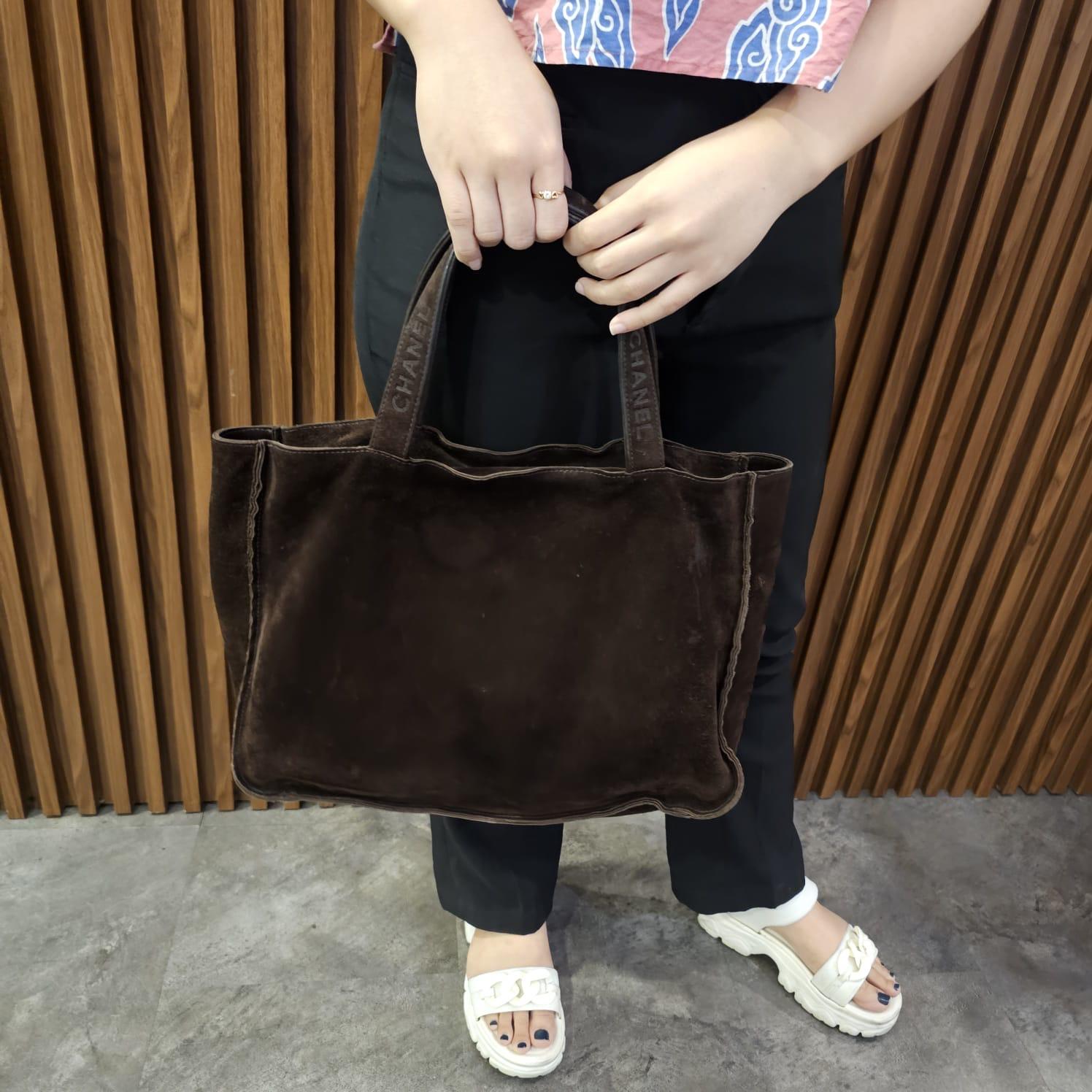 Chanel vintage tote pequeño de ante en color marrón oscuro. Tamaño perfecto para el bolso de todos los días. Ligeras marcas en el ante debidas al almacenamiento y al uso. Serie nº 5. Viene con el holo intacto, tarjeta de autenticidad y recibo de