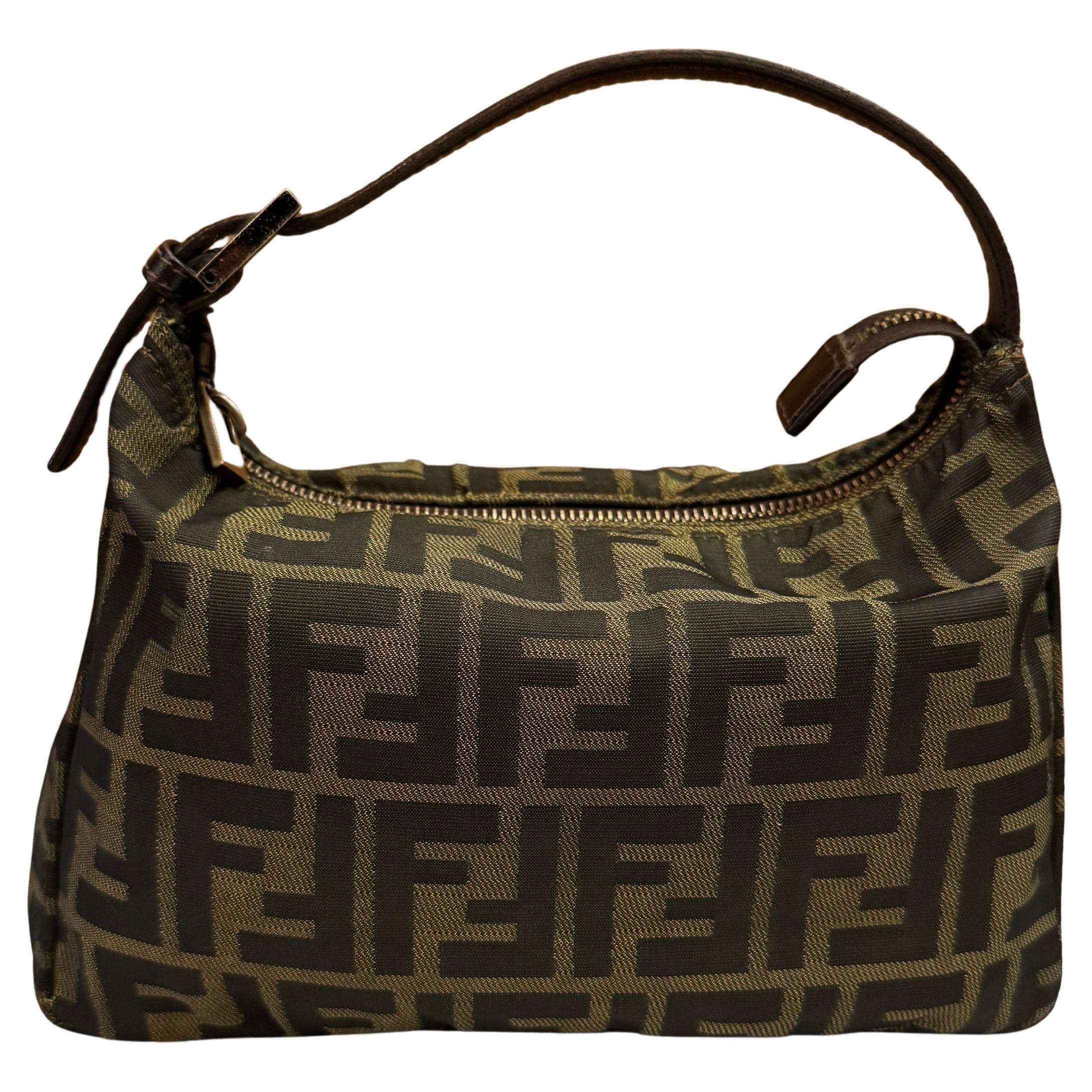 This vintage Fendi pouch handbag is crafted of Fendi's iconic brown Zucca jacquard featuring black chrome toned hardware. Top zipper closure opens black fabric interior. Made in Italy. Measures 9.5 x 6.5 x 4 inches Drop 4 inches. Compact in size but