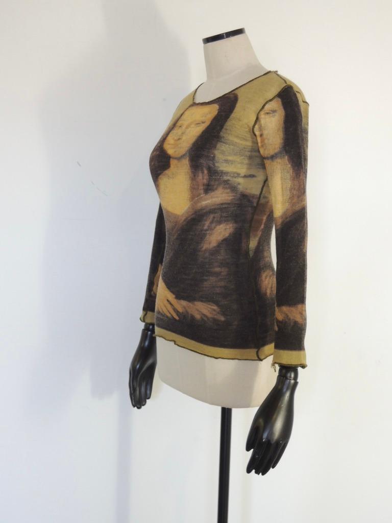 Vintage Jean Paul Gaultier Maille Femme shirred mesh top with a Mona Lisa motif. Scoop neck front, raw hems. Made in Italy. 

Unfortunately the top is in poor condition. While there are no stains, there are two holes and a tear as well as a worn