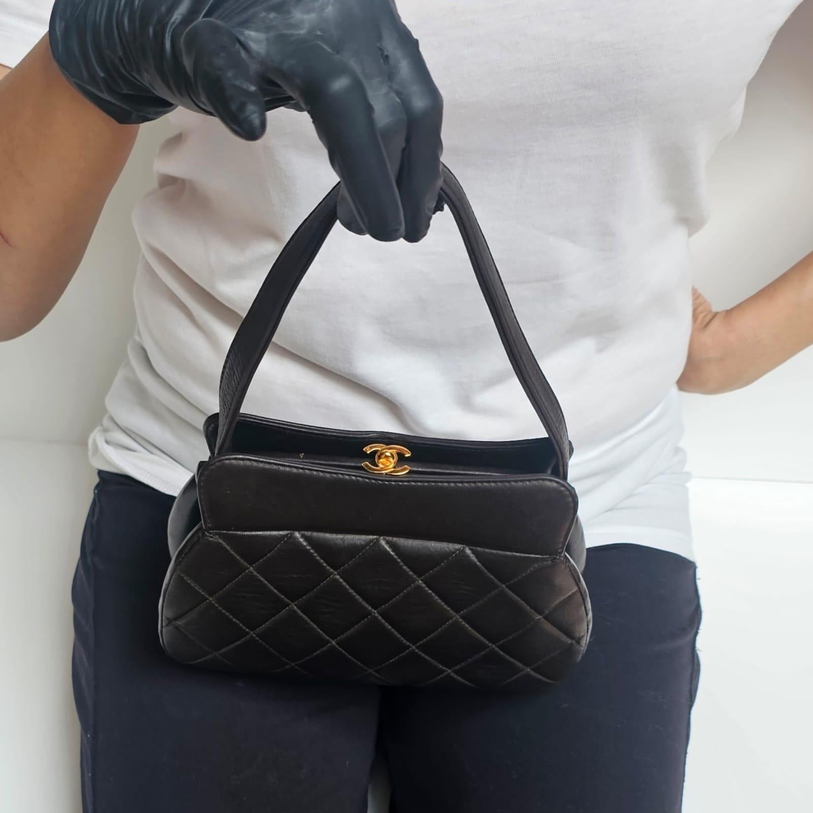 Mini lambskin quilted kiss lock purse in black with gold hardware. Beautiful vintage condition, with slight scuffing and press marks. Series #4. Comes with its card.