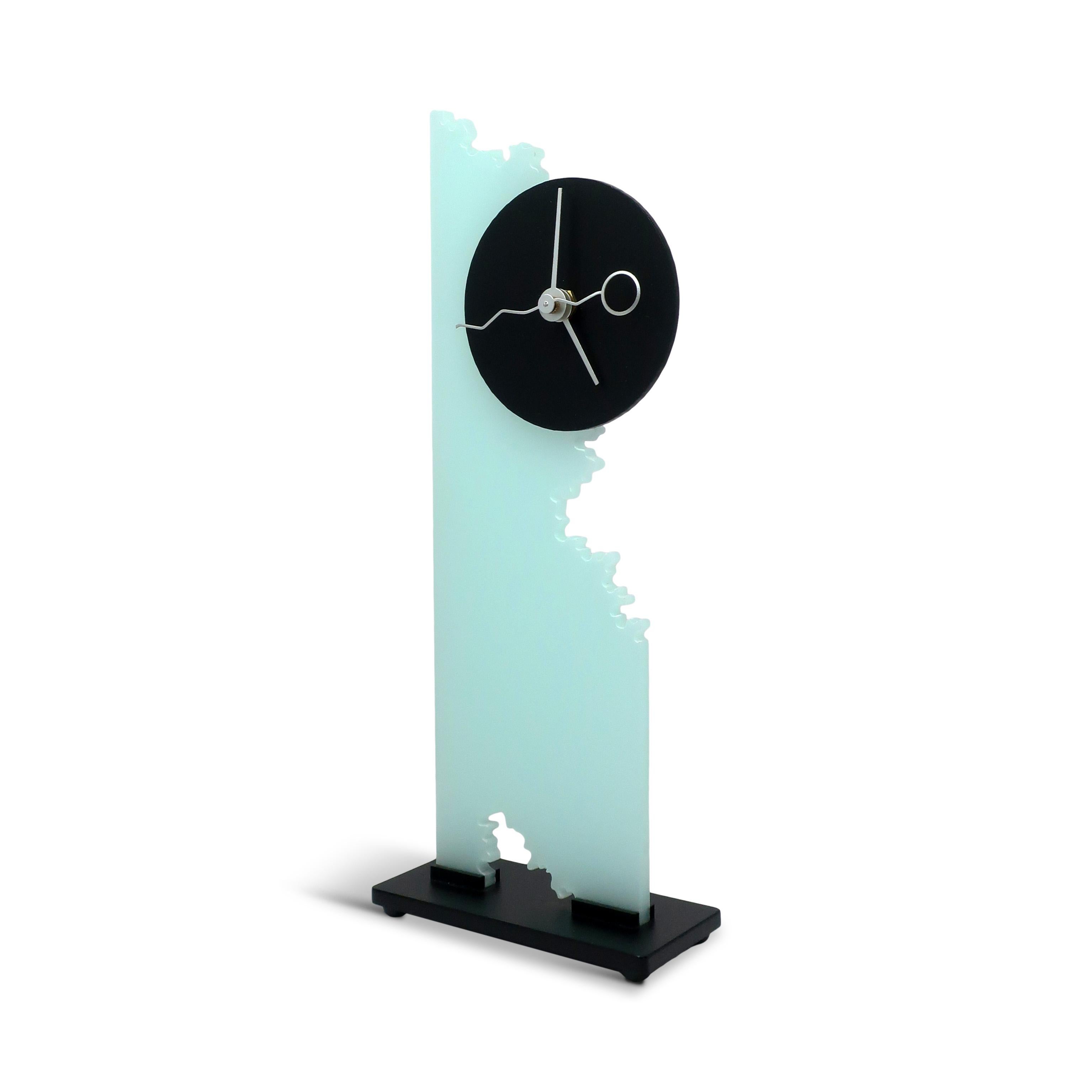 A unique desk or mantle clock is a fantastic example of late 1980s or early 1990s postmodern design, created by Brian Prothro for Zipadeedoodah Designs. It features a striking combination of frosted lucite, black accents, and a sleek geometric