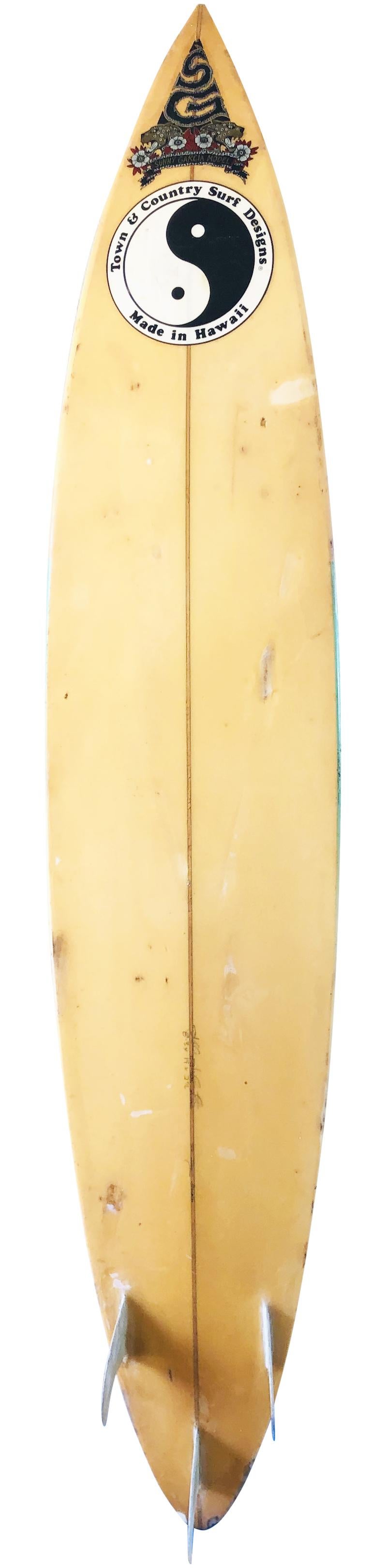 Early 1990s Town & Country Sunny Garcia model surfboard shaped by Jeff Johnston. Made for the 2000 ASP World Champion, Sunny Garcia. Features a round pin design with glassed on thruster (tri-fin) setup. Featuring rare Sunny Garcia model laminate