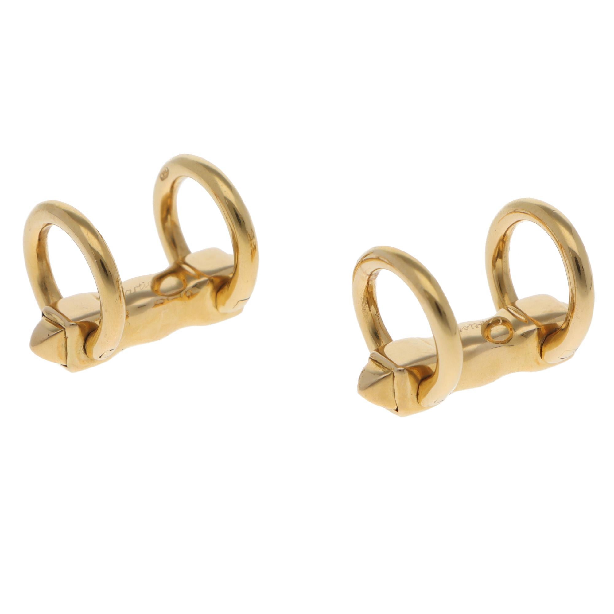 Boutons de manchette classiques en or jaune 18 carats de Cartier datant de 1991.

Chaque bouton de manchette est composé de deux bandes rondes reliées par une barre, ce qui permet de les mettre et de les enlever facilement. De par leur design et
