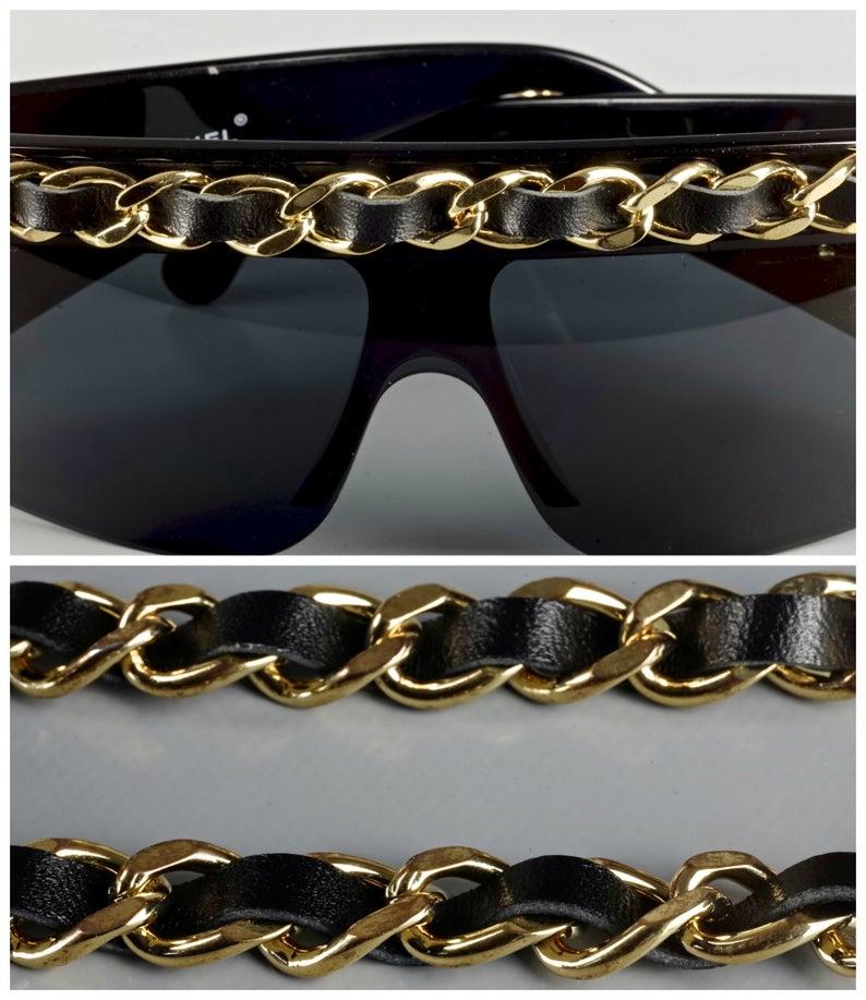 Vintage 1992 CHANEL Iconic Leather Chain Drop Sunglasses

Measurements:
Height: 2.36 inches (6 cm)
Frame Width: 5.51 inches (14 cm)
Temples:  4.48 inches (11.4 cm)
Chain: 26.96 inches (68.5 cm)

As seen on Rihanna, Amber Rose and Lady Gaga. These
