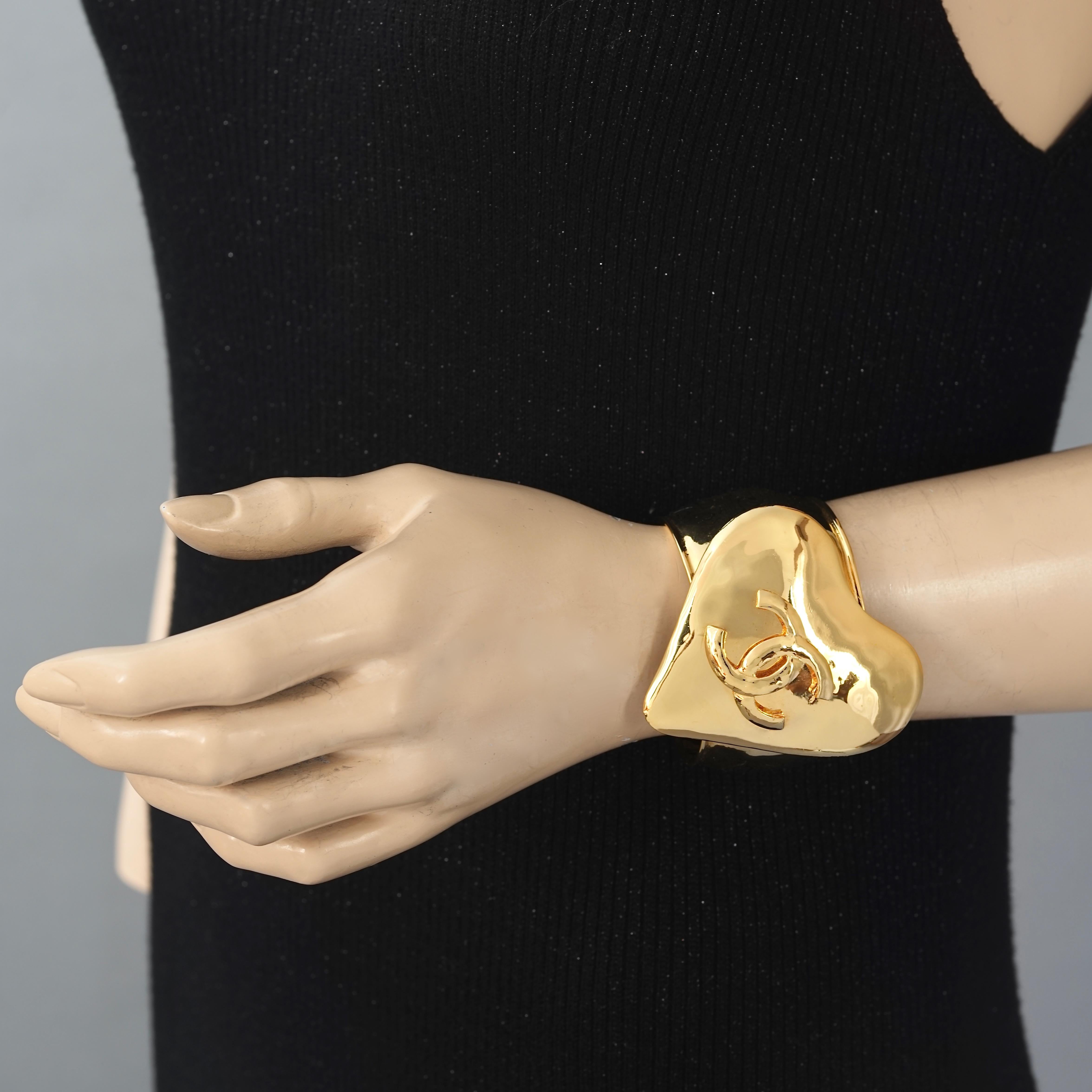 Vintage 1993 CHANEL Logo Heart Cuff Bracelet

Measurements:
Height: 2.51 inches (6.4 cm)
Total Circumference: 6.96 inches (17.7 cm) including opening

Features:
- 100% Authentic CHANEL.
- Massive heart center piece with embossed CC logo.
- Signed