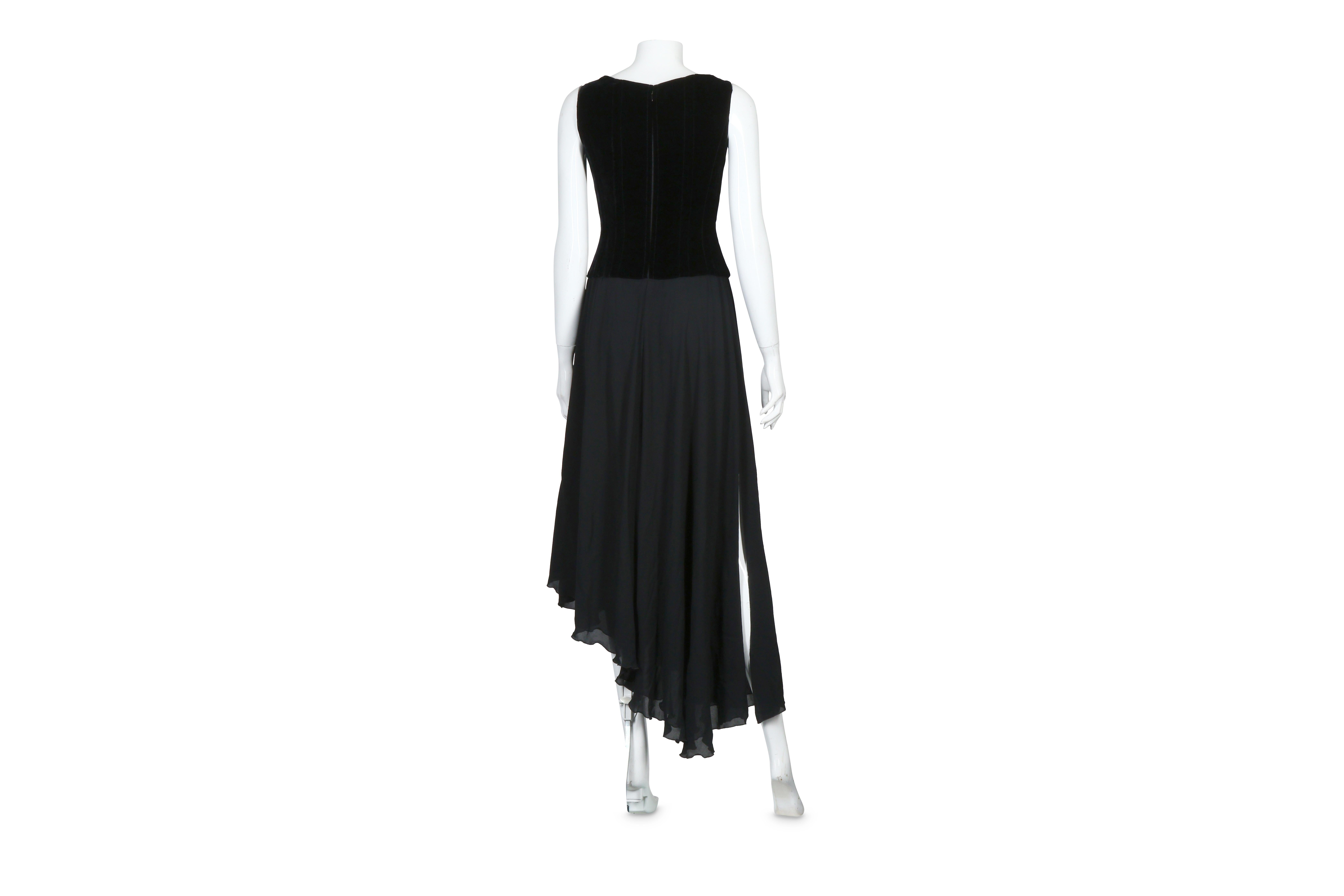 Chanel 1993 F/W black velvet boned corset dress with asymmetric, double-layered silk blend skirt w/thigh-high slit (at the longer side of the skirt) and finished with a lettuce hem. There is an interior belt at the waist, a hidden zipper at center