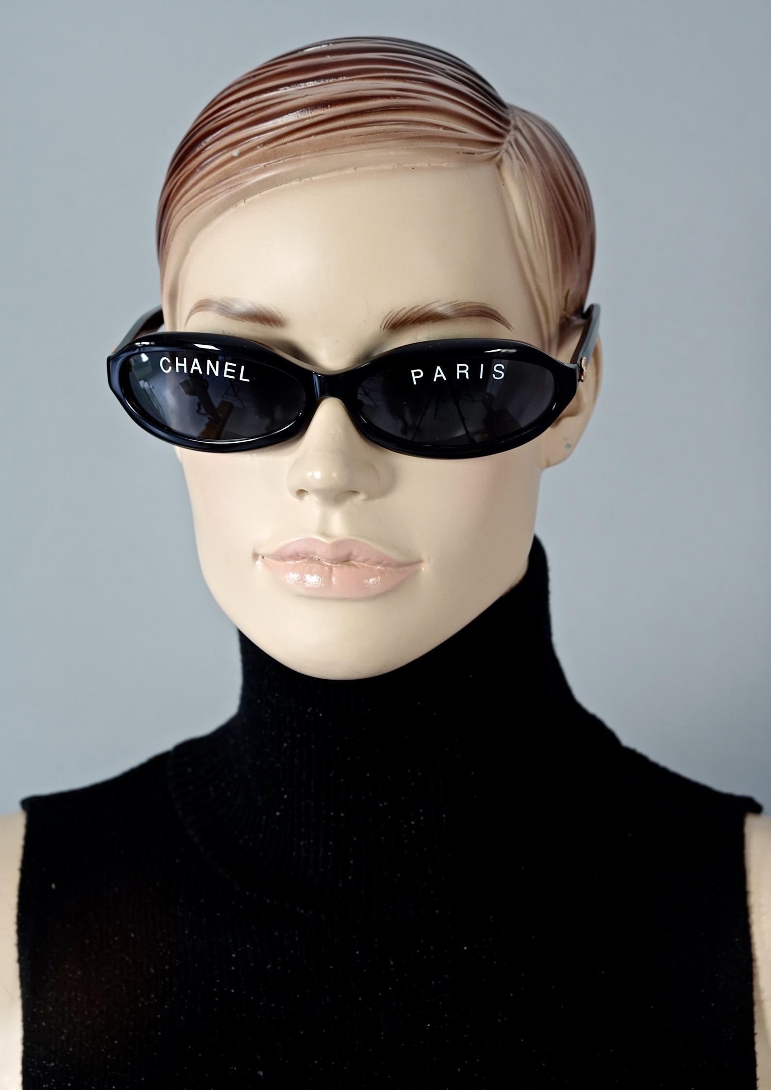 Vintage 1993 Iconic CHANEL PARIS Spelled Narrow Frame Black Sunglasses

Measurements:
Height: 1.57 inches (4 cm)
Frame Width: 5.63 inches (14.3 cm)
Temples: 5.11 inches (13 cm)

From CHANEL Spring/ Summer 1993 collection.

Features:
- 100% Authentic