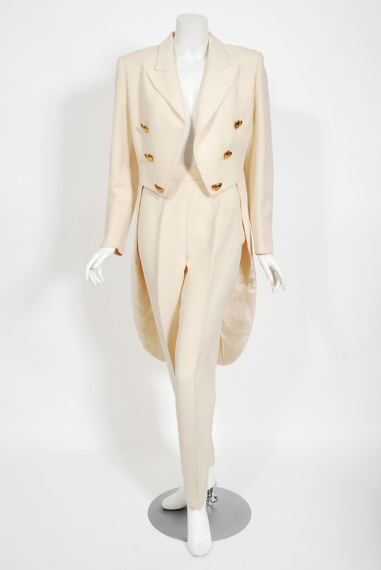Exquisite Moschino Couture cream wool heart-buttons tuxedo pantsuit dating back to his 1993 fall-winter Hearts Collection. Moschino called himself half tailor, half artist; although he did not cut or sew, he drew frequently, quickly, and