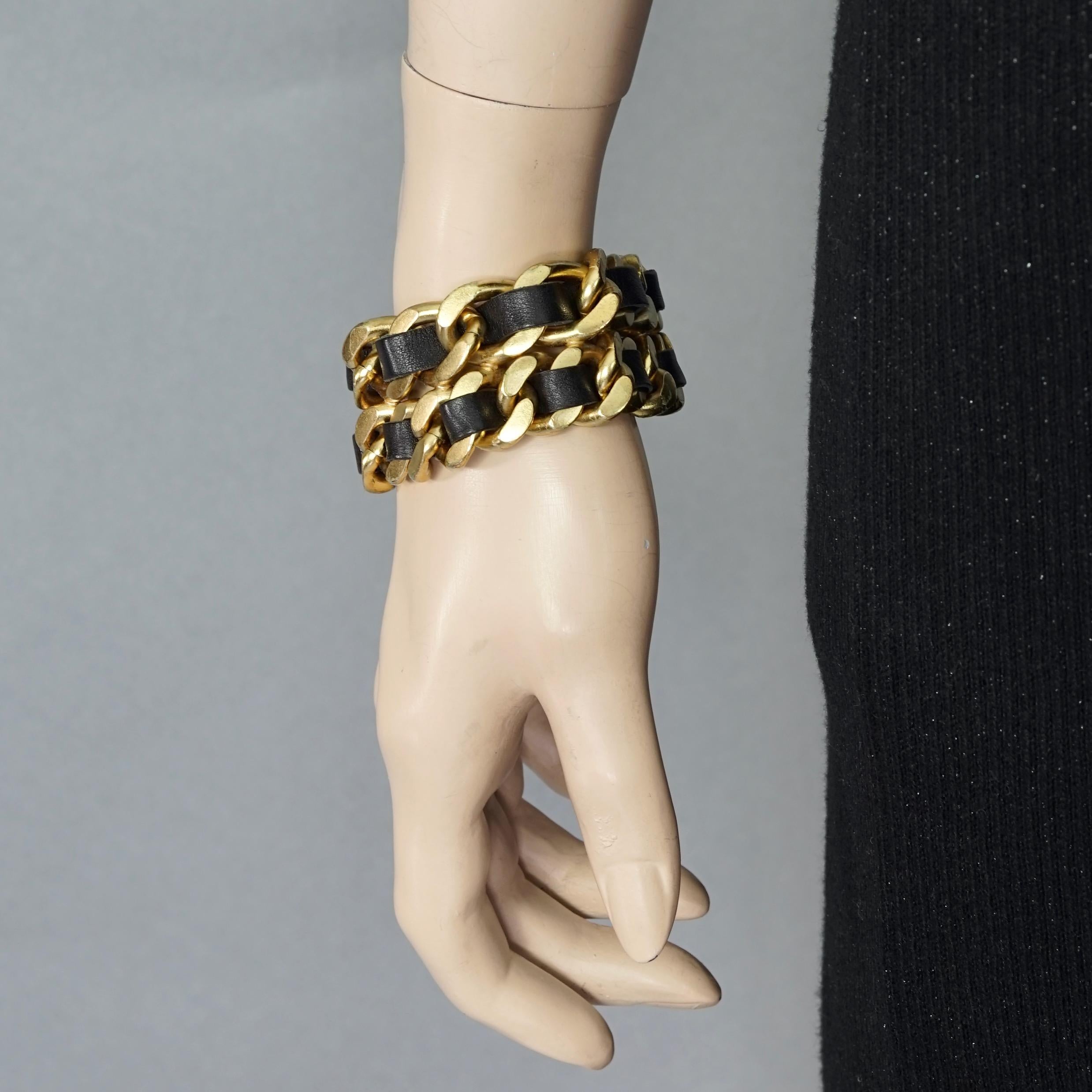 Vintage 1995 CHANEL Double Leather Chain Cuff Bracelet

Measurements:
Height: 1.22 inches (3.1 cm)
Wearable Length: 7.48 inches (19 cm)

Features:
- 100% Authentic CHANEL.
- Double tiered interlaced chain and black leather.
- Gold tone hardware.
-