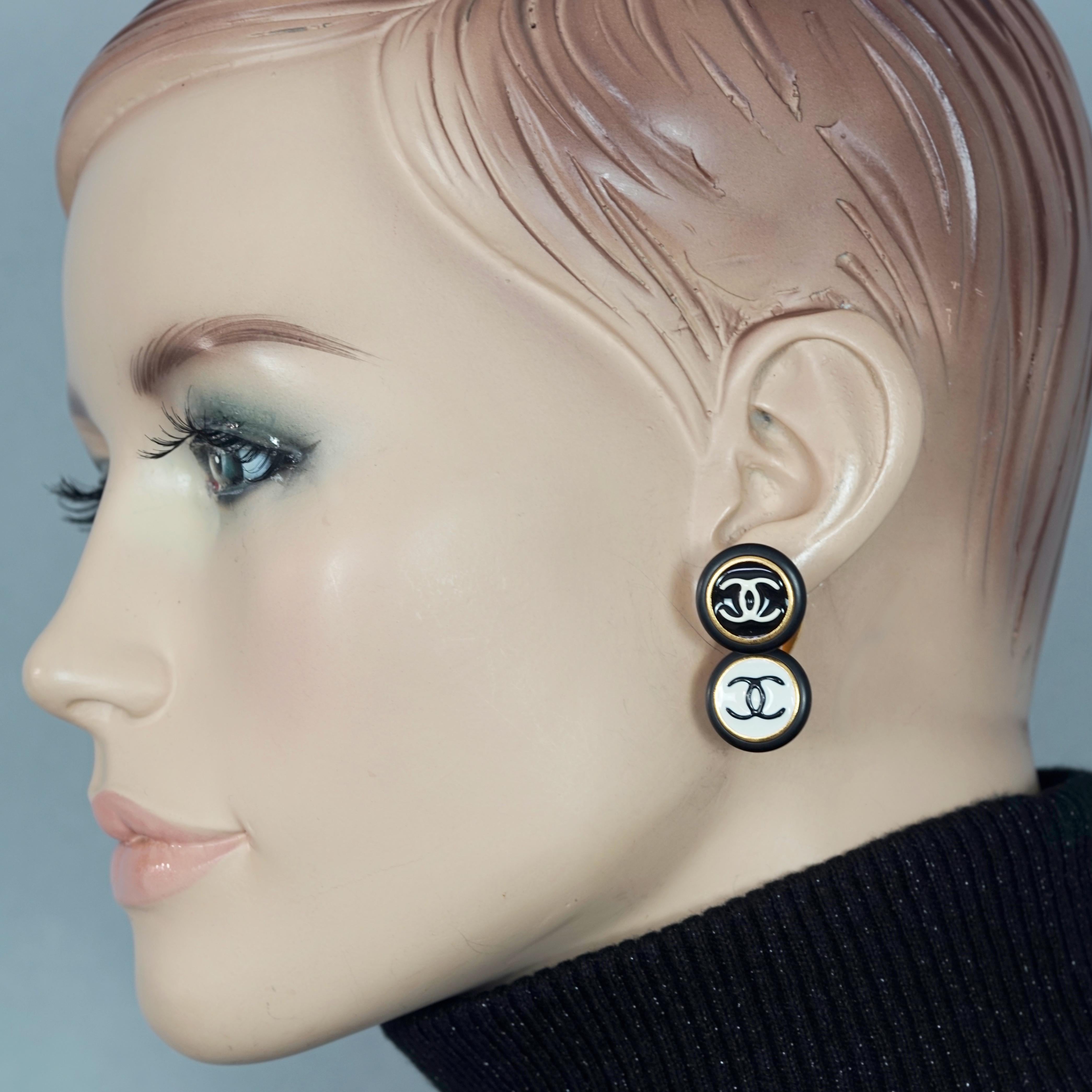 Vintage 1995 CHANEL Logo Double Disc Black and White Enamel Earrings

Measurements:
Height: 1.34 inches (3.4 cm)
Width: 0.71 inch (1.8 cm)
Weight per Earring: 11 grams

Features:
- 100% Authentic CHANEL.
- Double disc black and white enamel CC