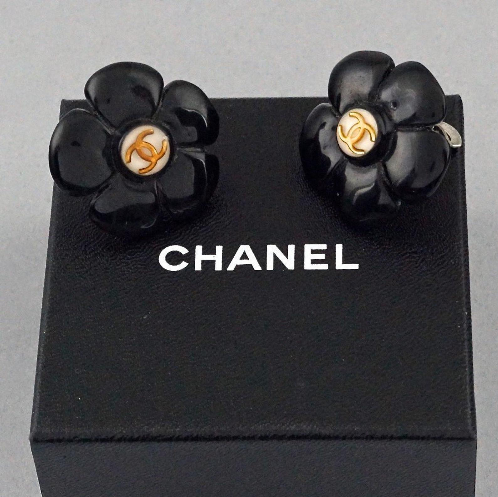 Vintage 1996 CHANEL Logo Black Flower Resin Pop Earrings

Measurements:
Height: 1.3 inches (3.3 cm)
Width: 1.3 inches (3.3 cm)
Weight per Earring: 7 grams

Features:
- 100% Authentic CHANEL.
- Black resin flower with gold CC logo at the centre.
-