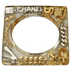 Bracelet manchette vintage CHANEL en plexiglas et breloques emblématiques carrées en forme de breloques, 1997