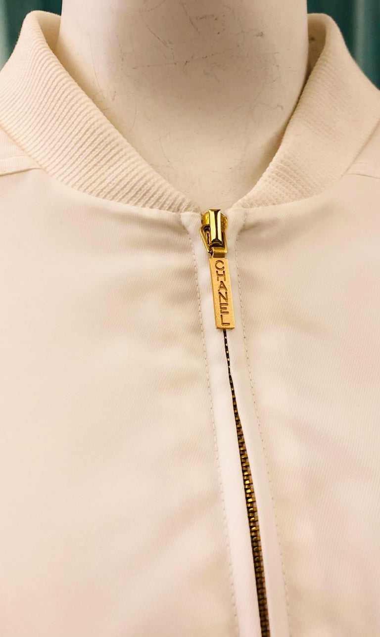 - Chanel white gathered bomber jacket from 1997 spring collection. 

- Ribbed details. 

- Gold hardware “Chanel” front zip fastening. 

- White and Gold “CC” button. 

- Two front flap pockets. 

- Elasticated waistband. 

- Full lining. 

-