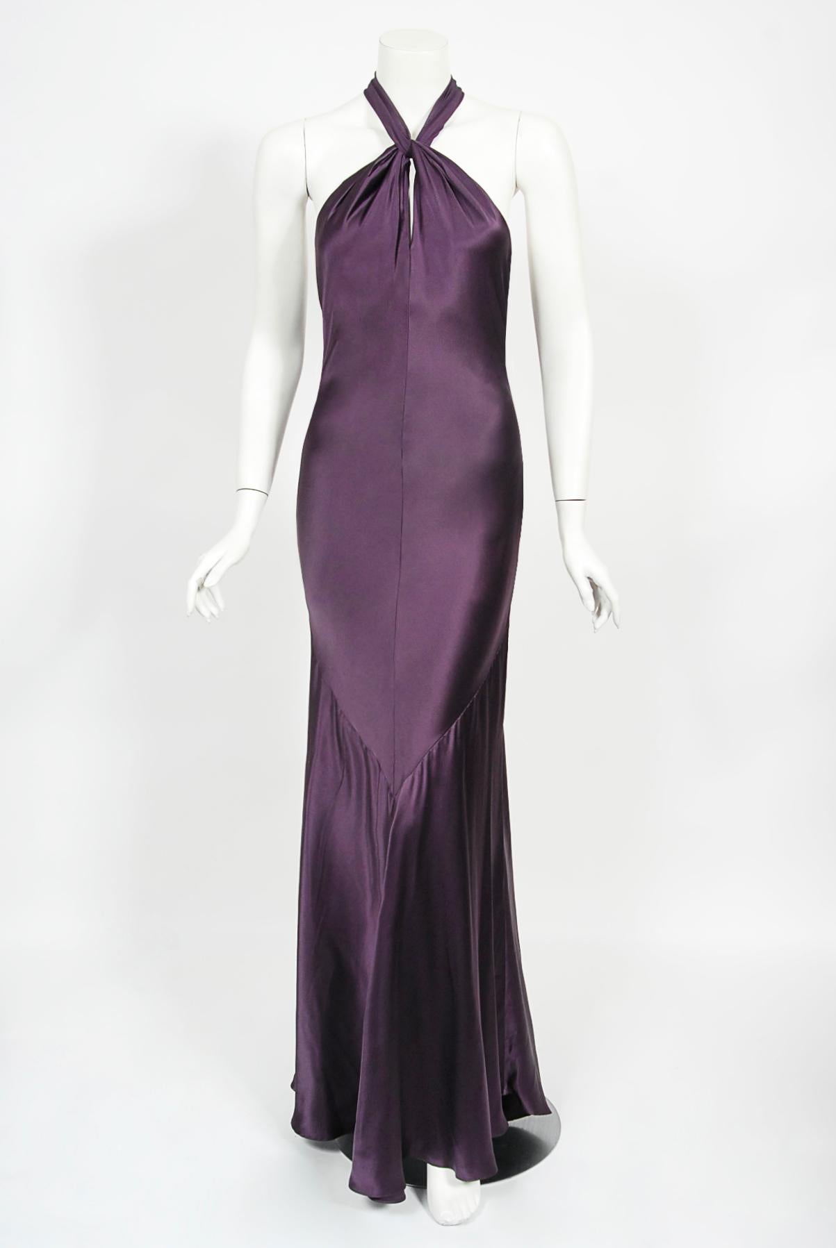 An exceptional and incredibly elegant Gianni Versace plum purple silk bias-cut gown dating back to the iconic 1998 spring-summer collection. Versace’s creations were enjoyed by the super wealthy but his impact was felt across a wider section of