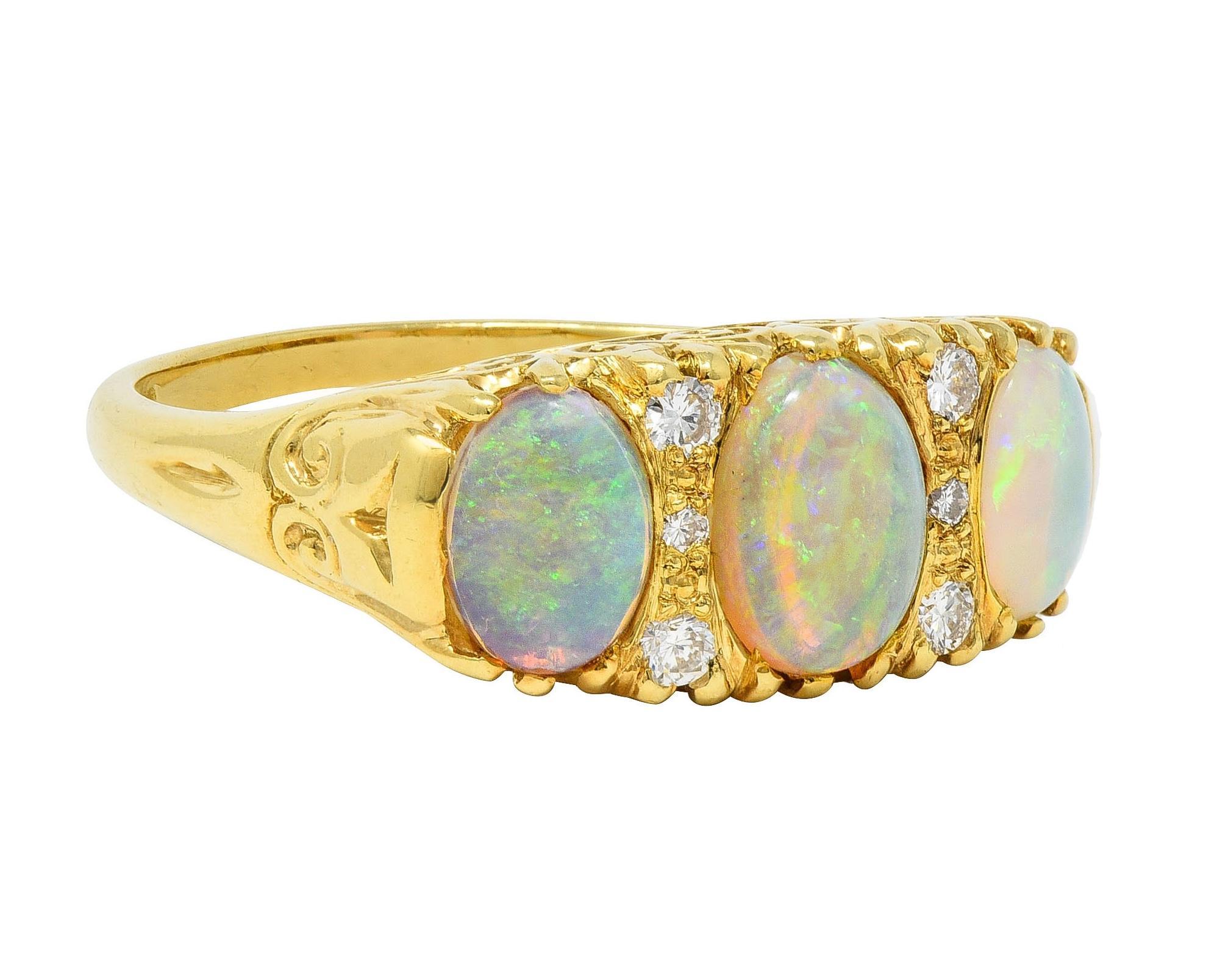 Featuring three oval shaped opal cabochons prong set east to west 
Graduated and ranging in size from 5.0 x 7.0 mm to 6.0 x 9.0 mm 
Translucent white in body color with strong blue and green play-of-color
Accented by round brilliant cut diamonds