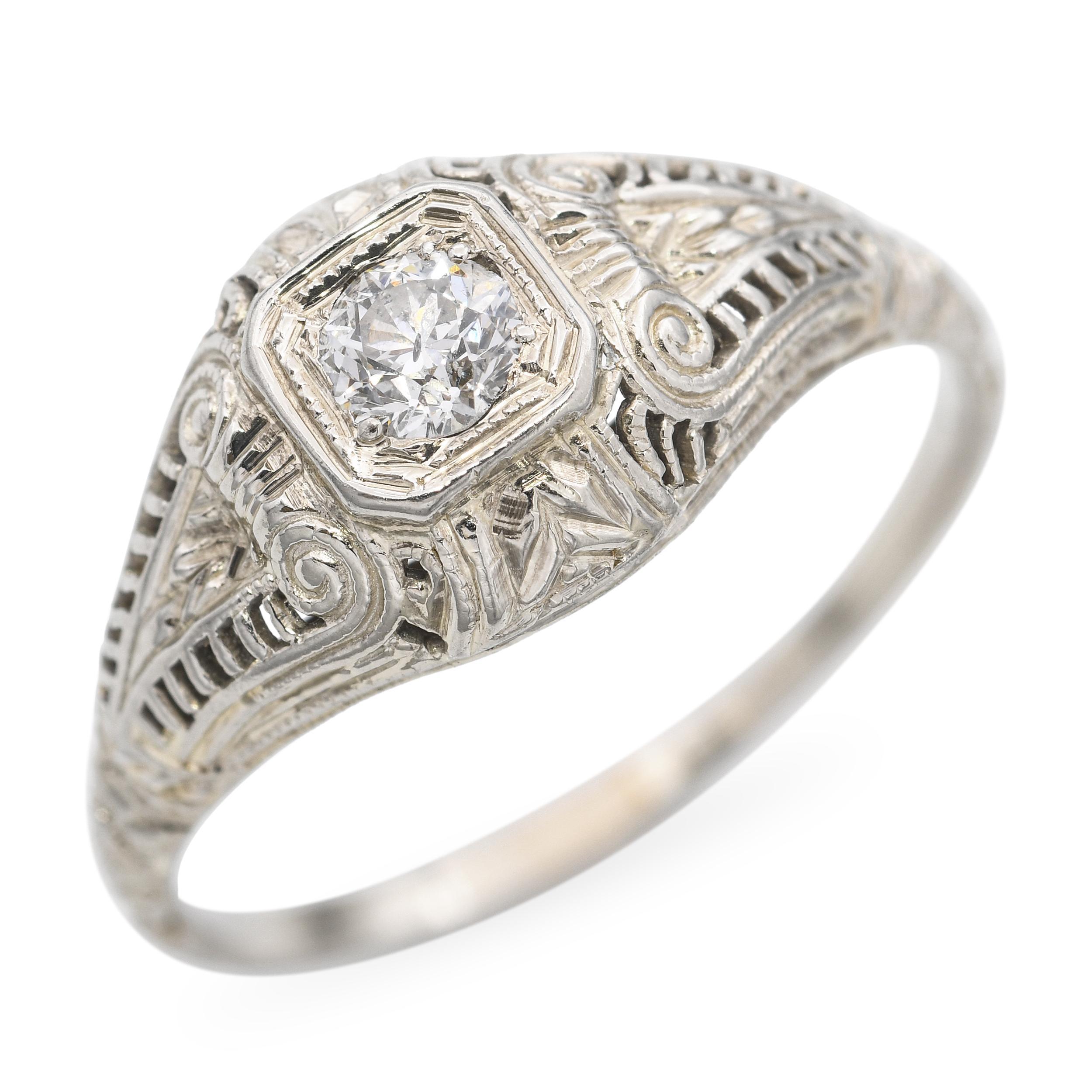 Questo elegante anello vintage è realizzato in oro bianco 19 carati e mette in mostra uno scintillante diamante da 0,26 carati. Il diamante è incastonato in un intricato disegno a filigrana, che riflette la delicata maestria artigianale e le