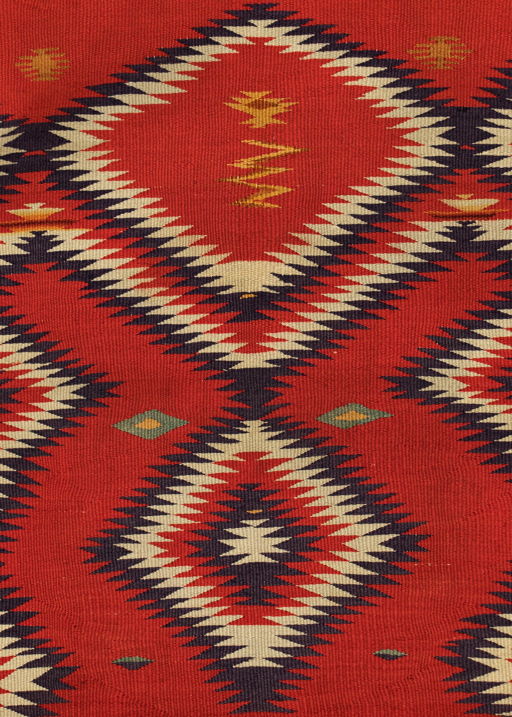 Authentic vintage 19th century circa 1890 Navajo textile in a single saddle blanket format woven of Germantown Yarns in an Eyedazzler pattern of vibrant colors including red, deep purple, white, green and yellow/gold. Germantown textiles like this