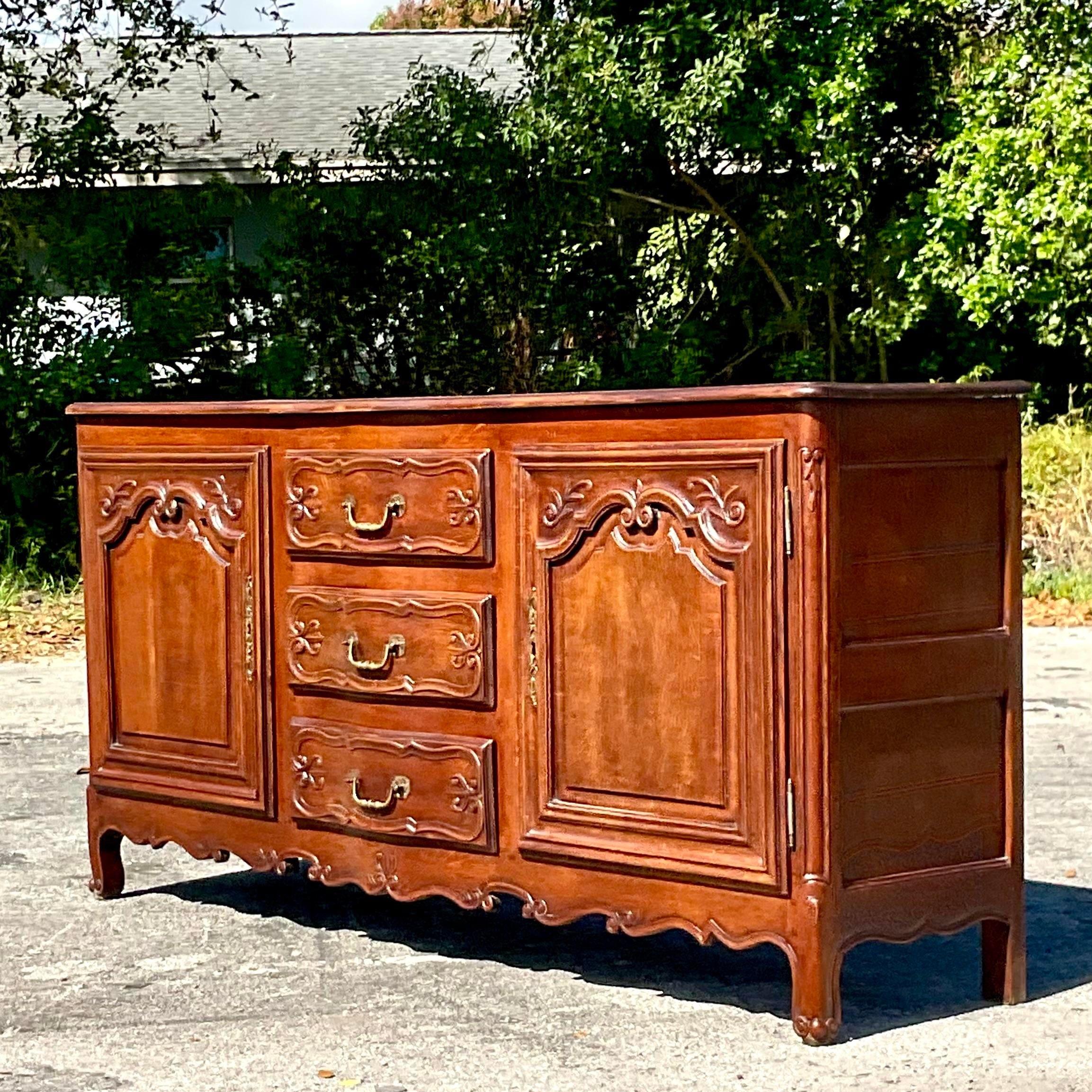 A stunning vintage 19th century Regency credenza. Beautiful hand carved detail and heavy brass hardware. Acquired from a Palm Beach estate.
