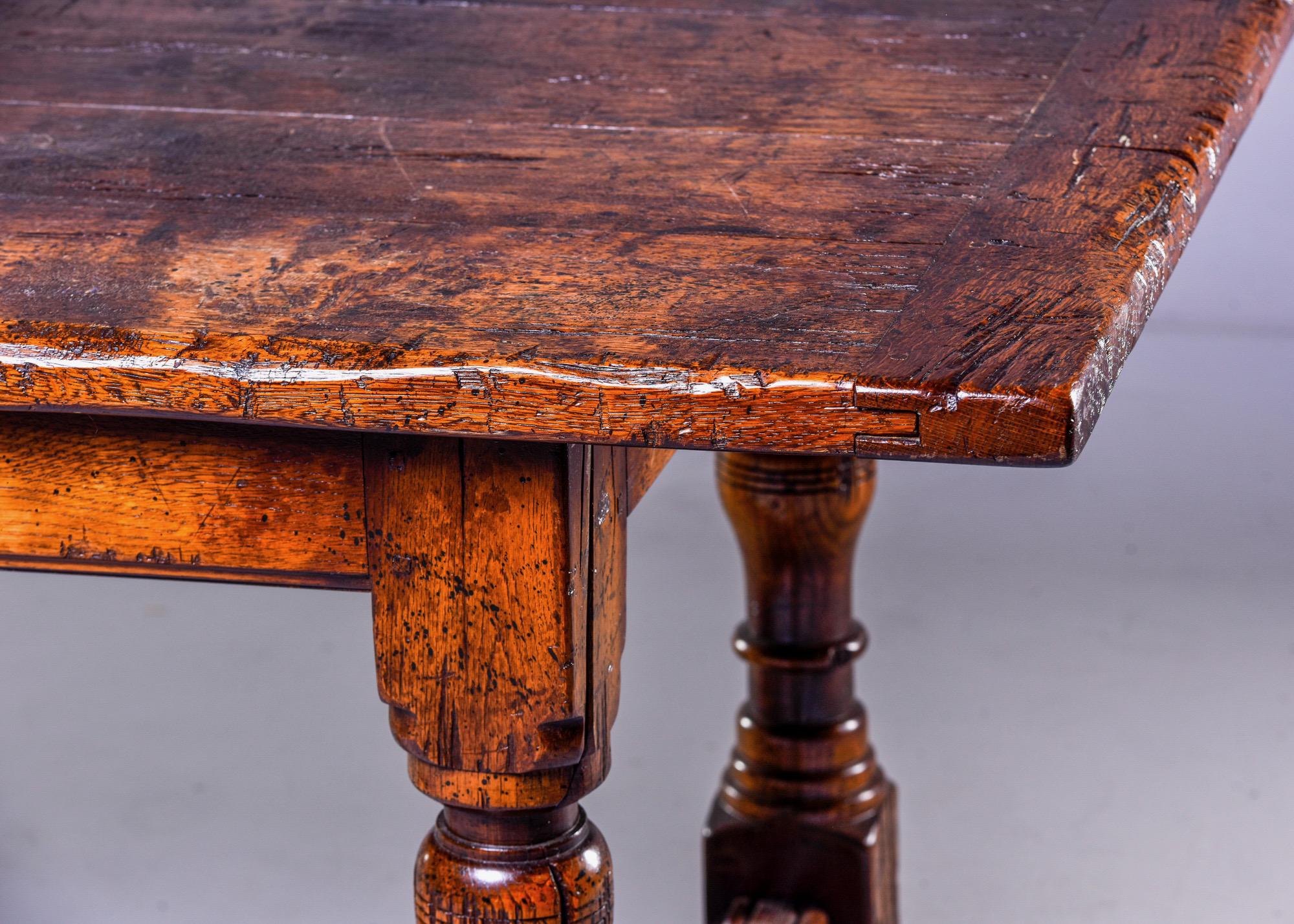 Found at high end estate, this circa 1990s top quality rustic dining table made in style of 19th century European farm table with heavy base, turned detail on legs and removable, distressed four plank top. Unknown maker.
