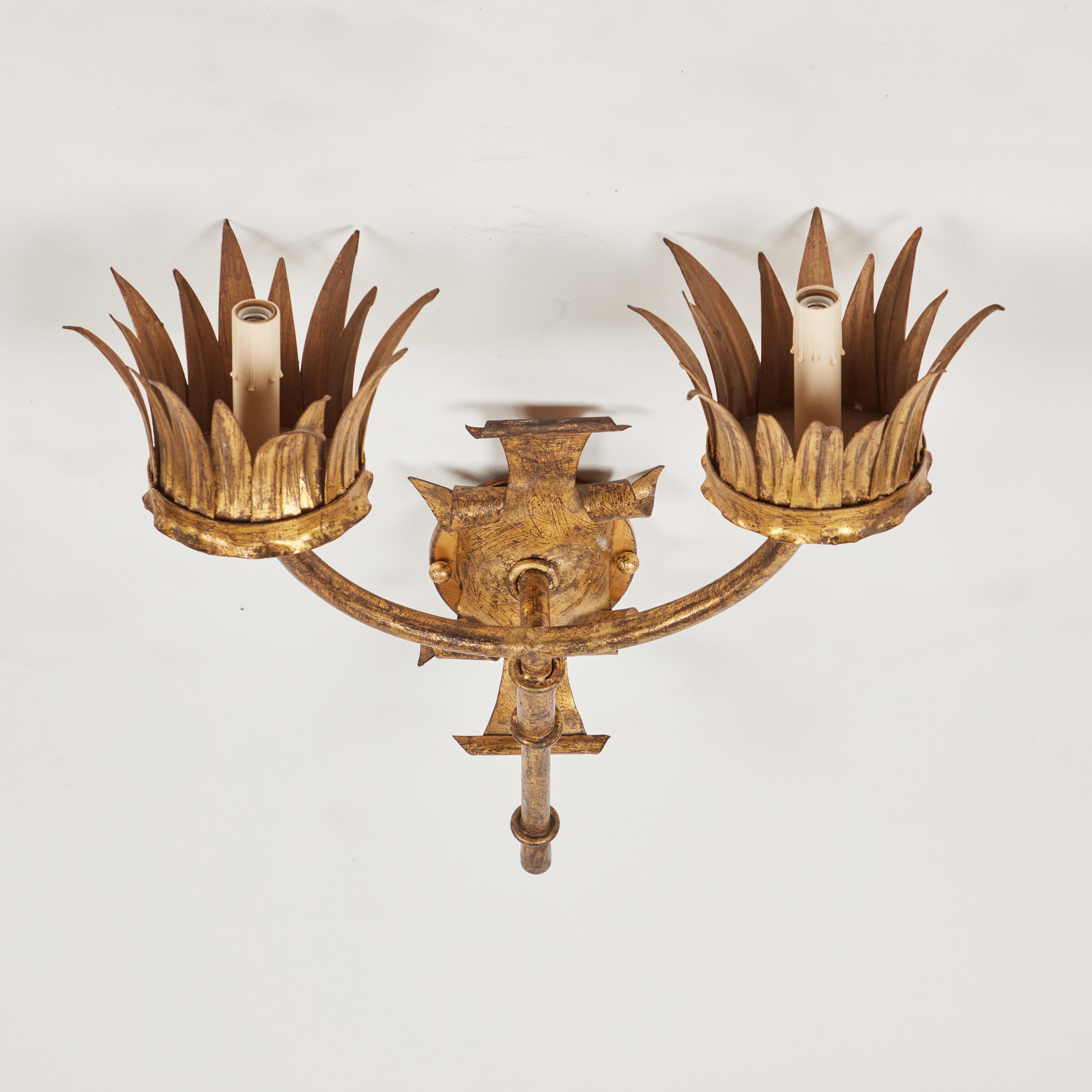 It has a lovely crown of leaves surrounding the light at the end of each arm, a rich gold leaf finish and has been newly rewired. This is a stunning accent on any wall. Made in Spain.


Measures: 18
