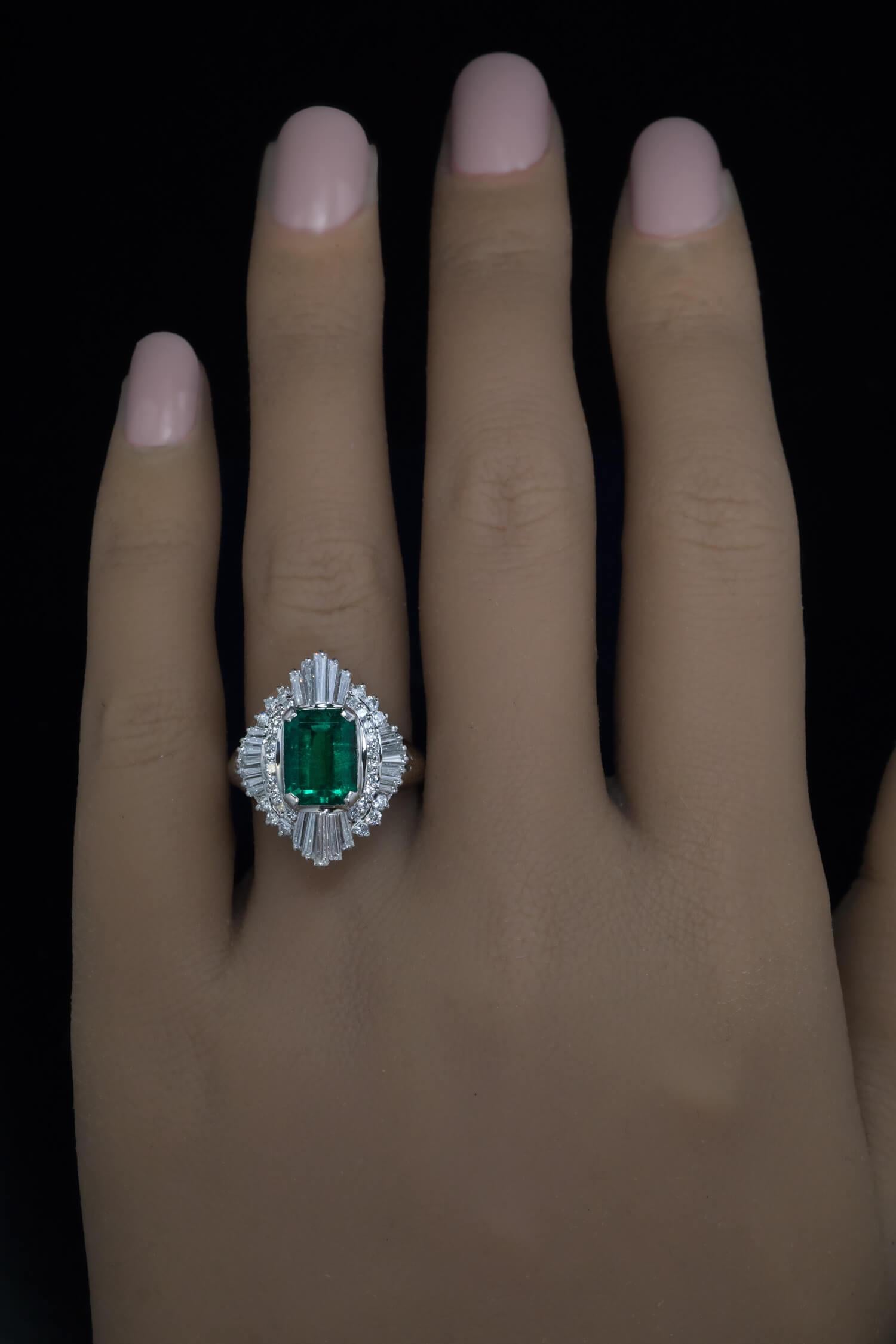 This well made ballerina style vintage platinum ring features a superb 2.01 ct Colombian emerald framed by tapered baguette and brilliant cut round diamonds. The emerald is very clean, of vivid bluish green color and rich color saturation. 