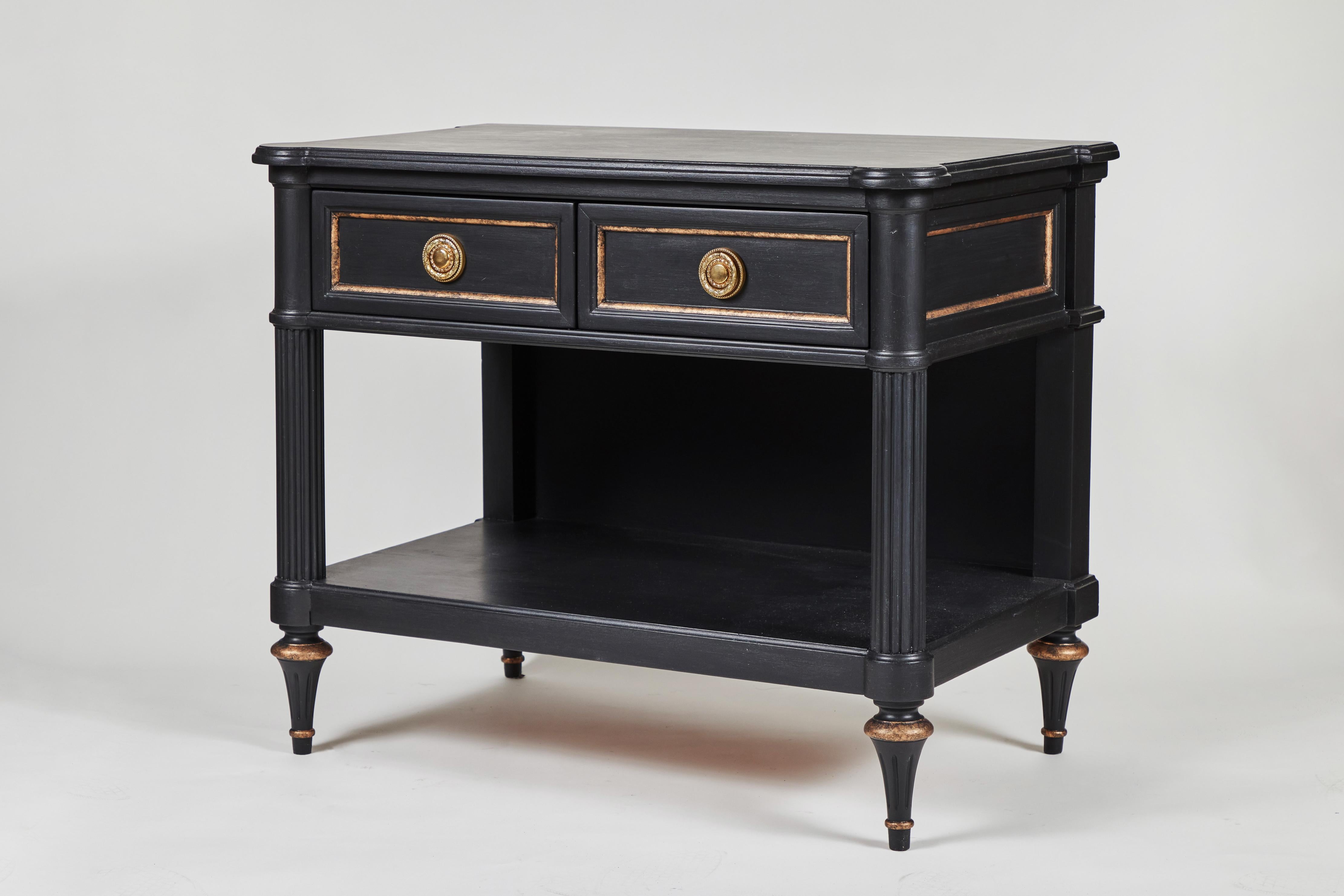 This vintage 2-drawer side table with bottom shelf has been newly painted in matte black with a detailed distressed gold accent. Bonus: One of the drawers has a hidden lock mechanism. 