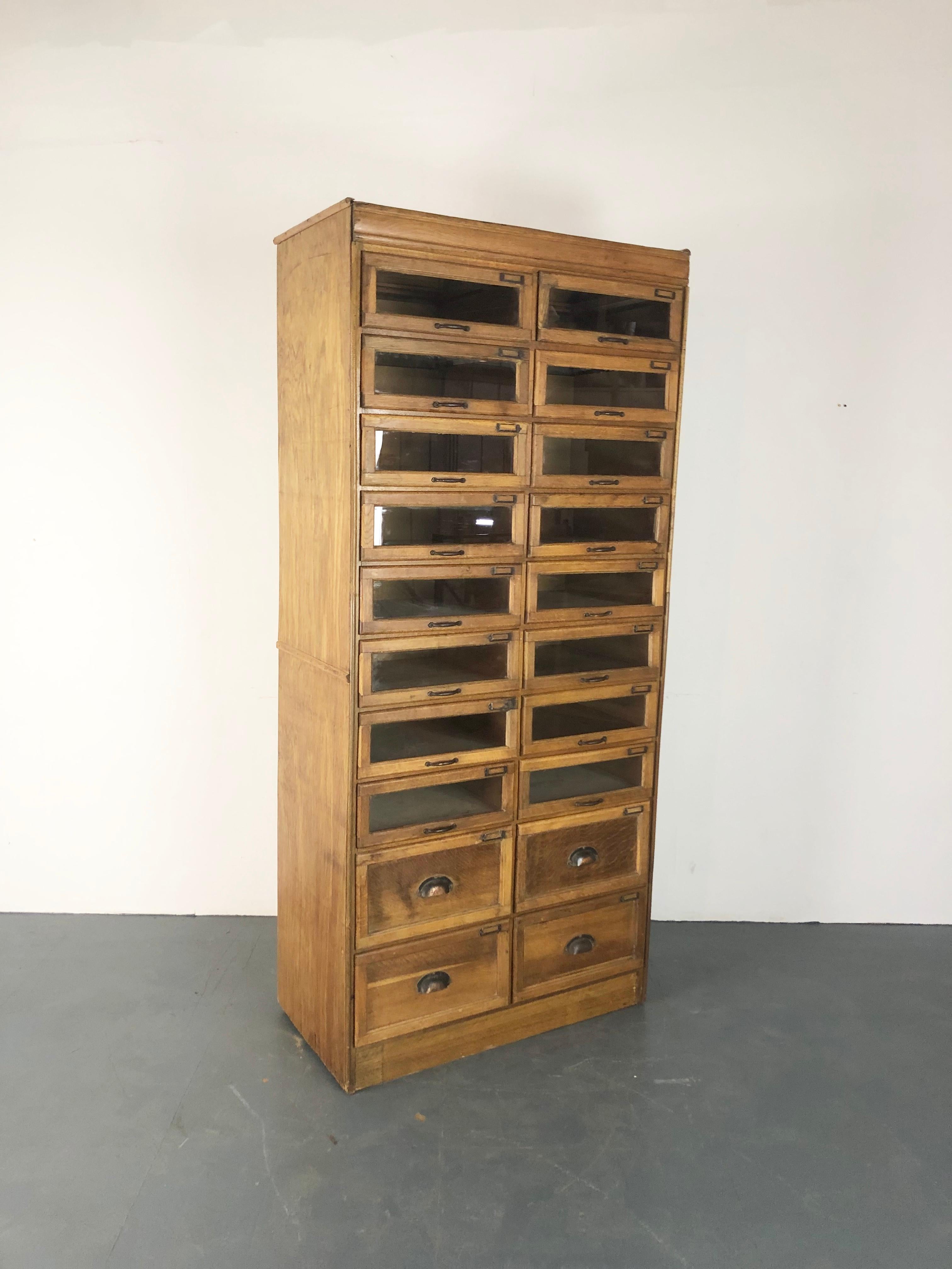 A very fine 20 drawer haberdashery shop cabinet from the first part of the 20th century.

It has 16 glass fronted drawers, all with brass handles and inserts, and four solid wooden base drawers. 

Approximate dimensions:

Height: