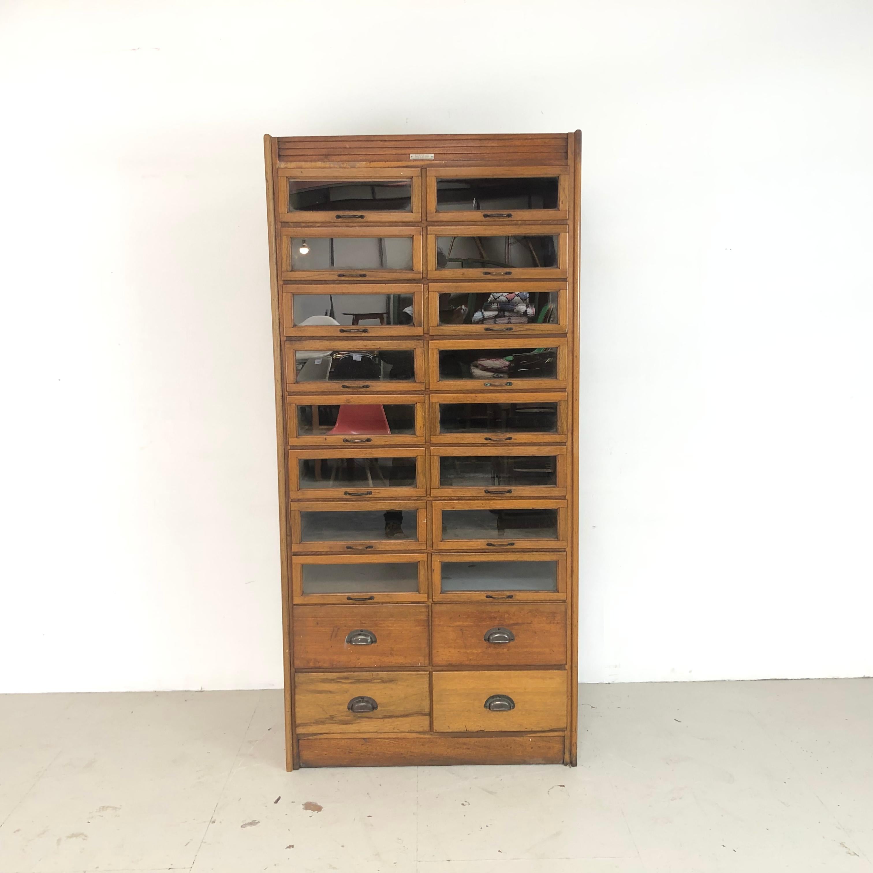 Really lovely vintage 20-drawer haberdashery shop cabinet from the 1920s with brass handles and panelled sides. Made by J C King.

In good vintage condition. Some scuffs here and there, commensurate with age, and signs of historical woodworm which