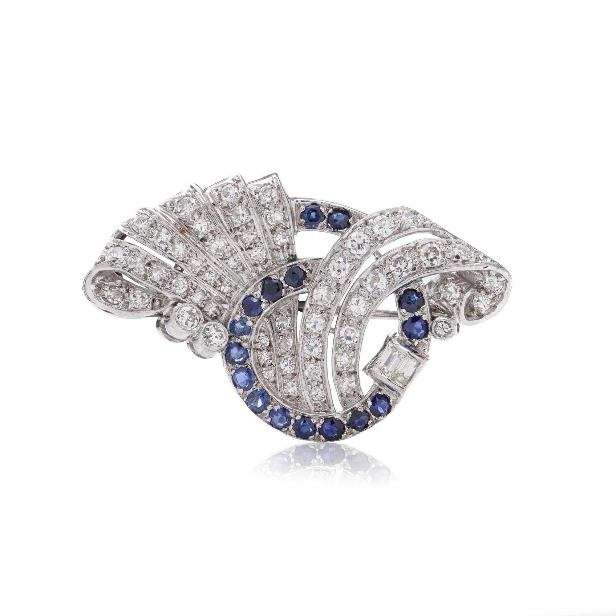 Broche vintage de diamantes y zafiros de 2,00 quilates con diseño de volutas. 

Engastada con diamantes talla brillante y baguette en una montura de metal blanco sin marcar que se prueba como oro de 12 quilates. Una pieza espejo de la versión con