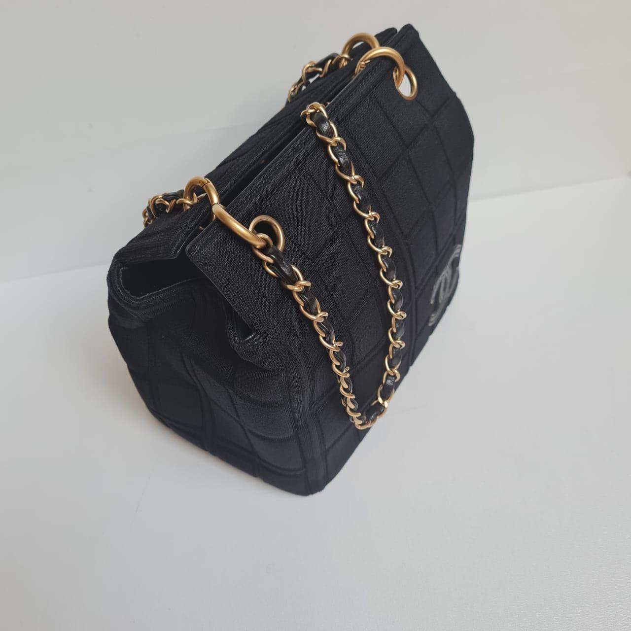 Vintage chanel chocolate bar quilted tote in black jersey. Overall in great condition, no visible rubbing on the jersey fabric. Light scratches on the leather flap top. Overall in great condition. Series #6. Comes with its authenticity card. 