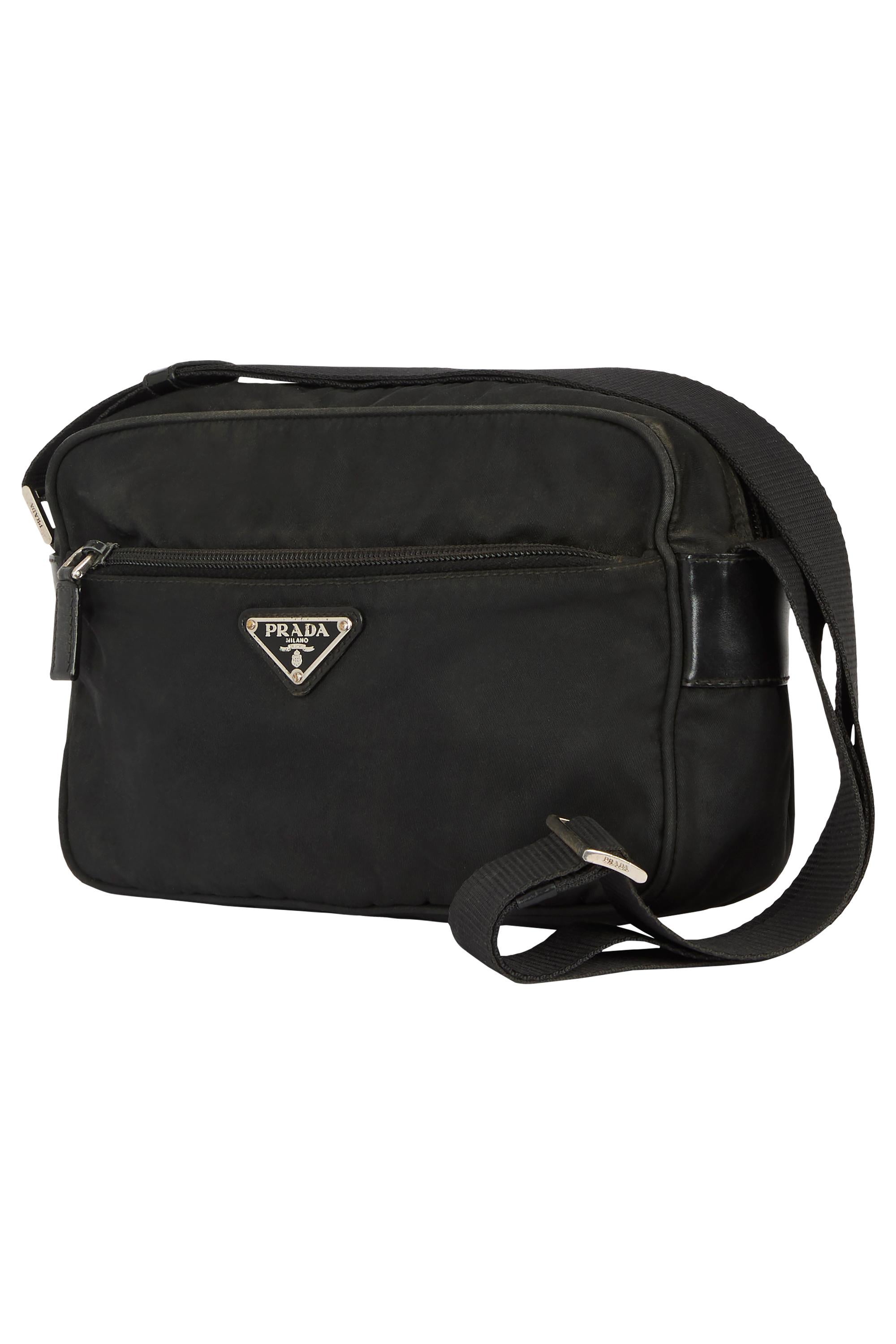 Bolso crossbody Prada vintage de los años 2000. Presenta un cuerpo de nailon negro, bolsillo delantero con cremallera , triángulo de esmalte negro con el logotipo de Prada. Compartimento principal con forro y bolsillo interior con cremallera. Correa