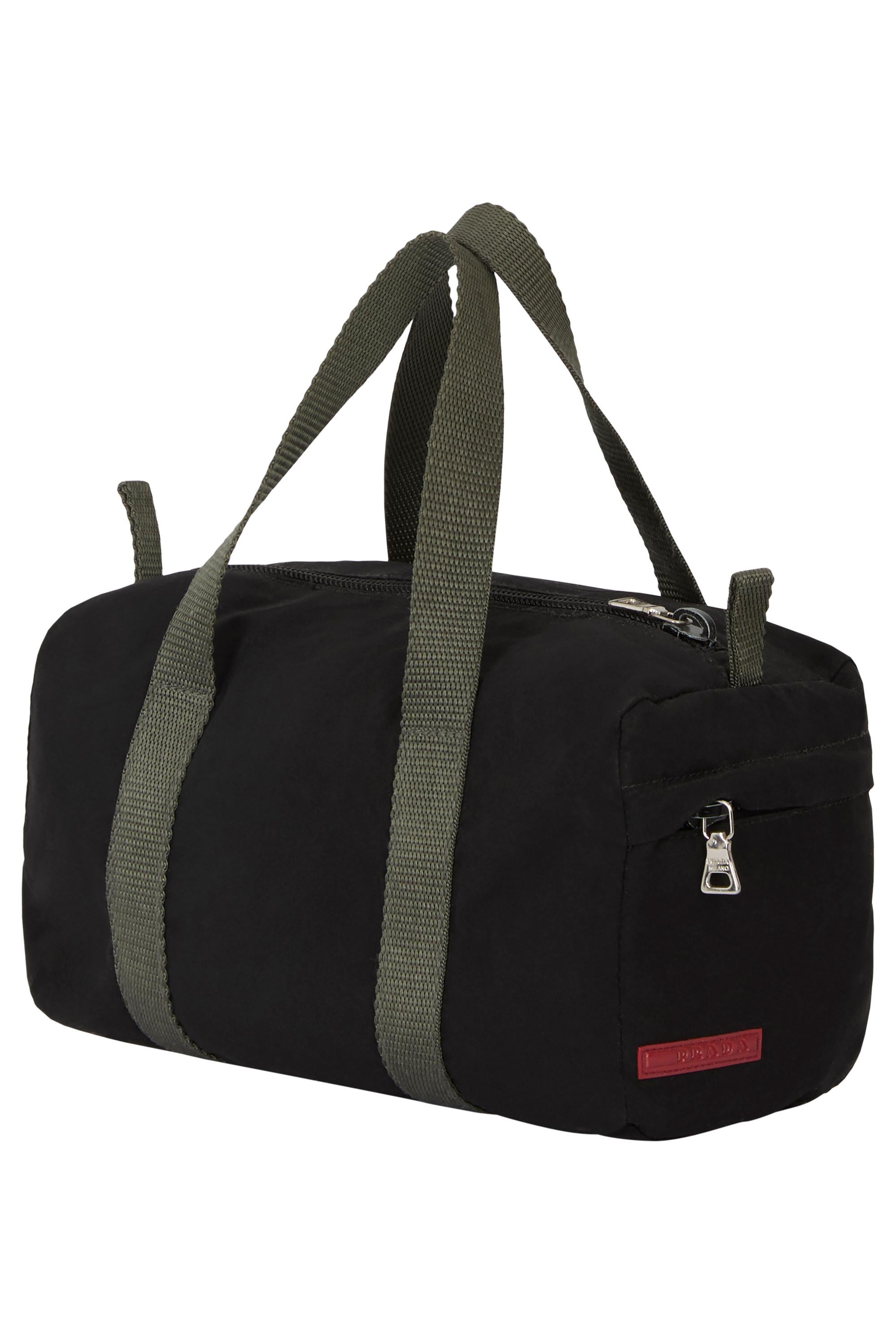 Vintage 2000's Prada mini fourre-tout en nylon noir.  Le corps est en nylon noir et les poignées sont grises. Mini poche latérale zippée avec le logo rouge de Prada en bas. Compartiment principal avec une doublure intérieure grise. Fermeture à