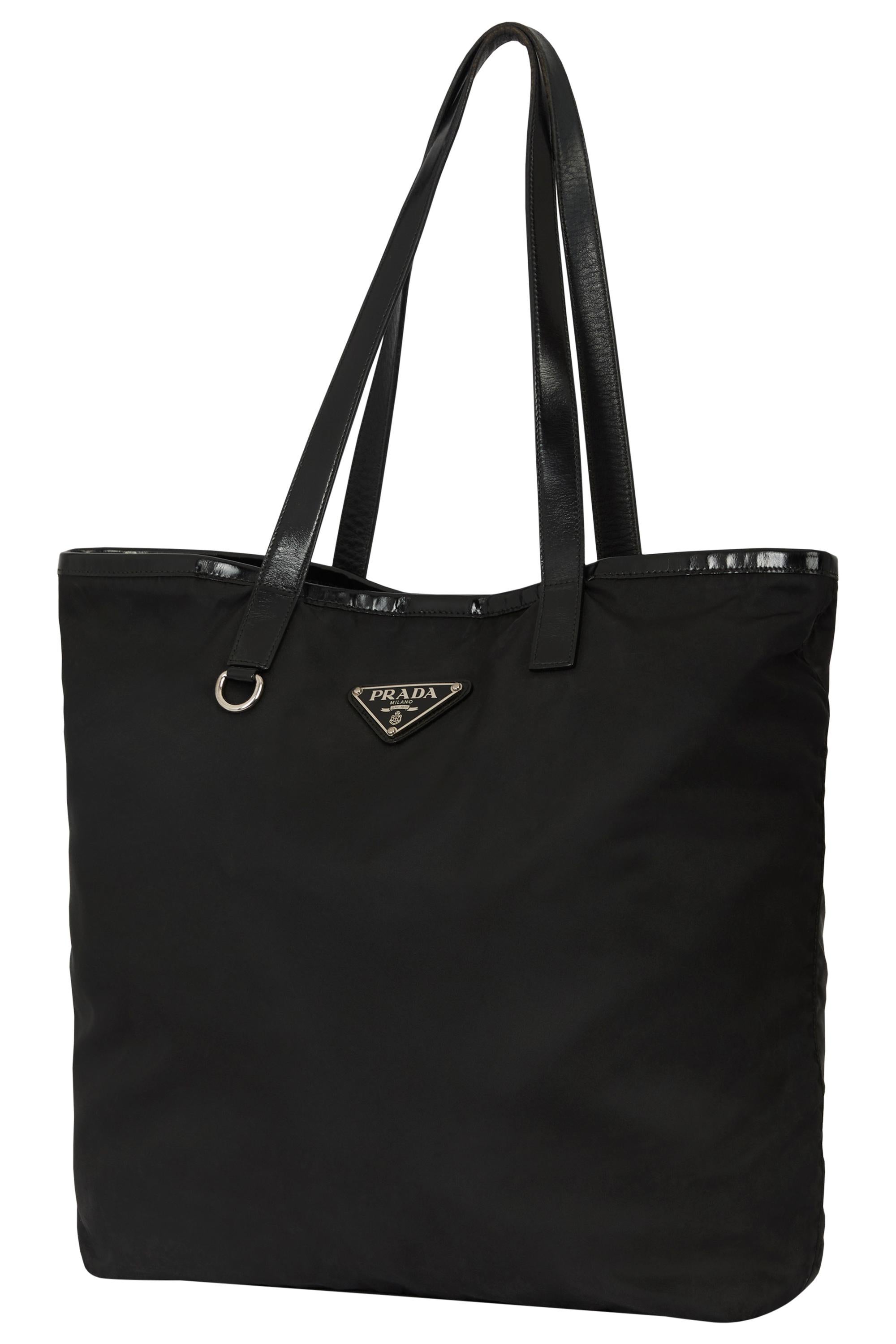 Sac fourre-tout noir Prada Vintage 2000's. Il est composé d'un corps en nylon noir, d'un triangle en émail noir et d'une garniture en cuir noir sur le dessus et sur les poignées. Compartiment principal avec poche intérieure zippée. Se ferme par un