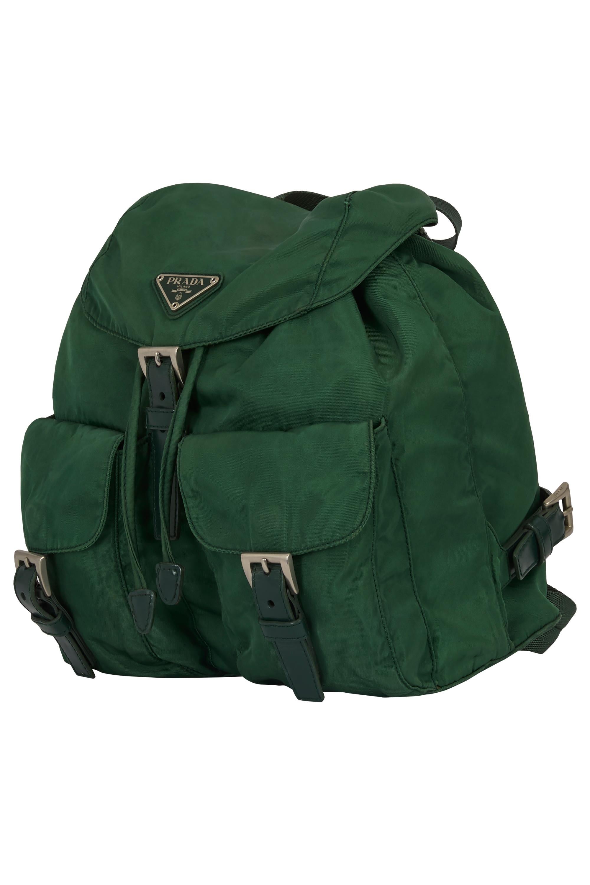 Sac à dos vert Prada Vintage 2000's. Il se compose d'un tissu en nylon vert, d'une fermeture à rabat classique avec boucle en cuir, de deux poches sur le devant complétées par un cordon de serrage dissimulé et du logo triangulaire en émail